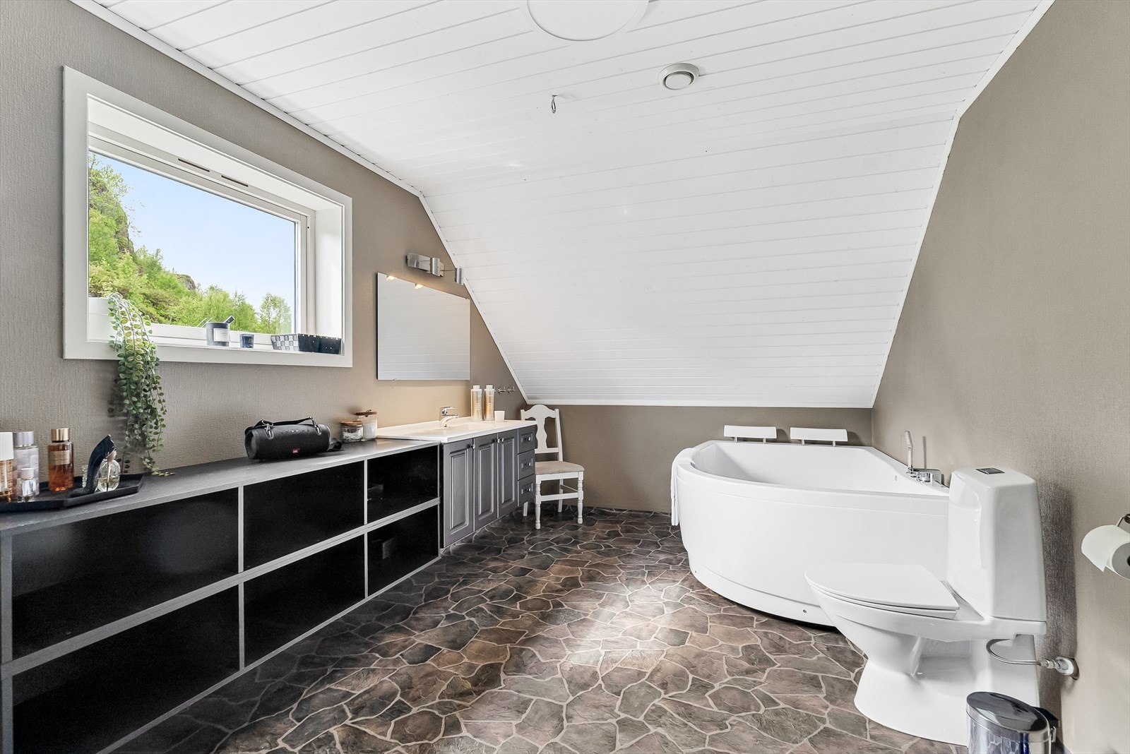 Bad 2.etasje innredet med hjørnebadekar, wc og innredning med servant. Galleribilde