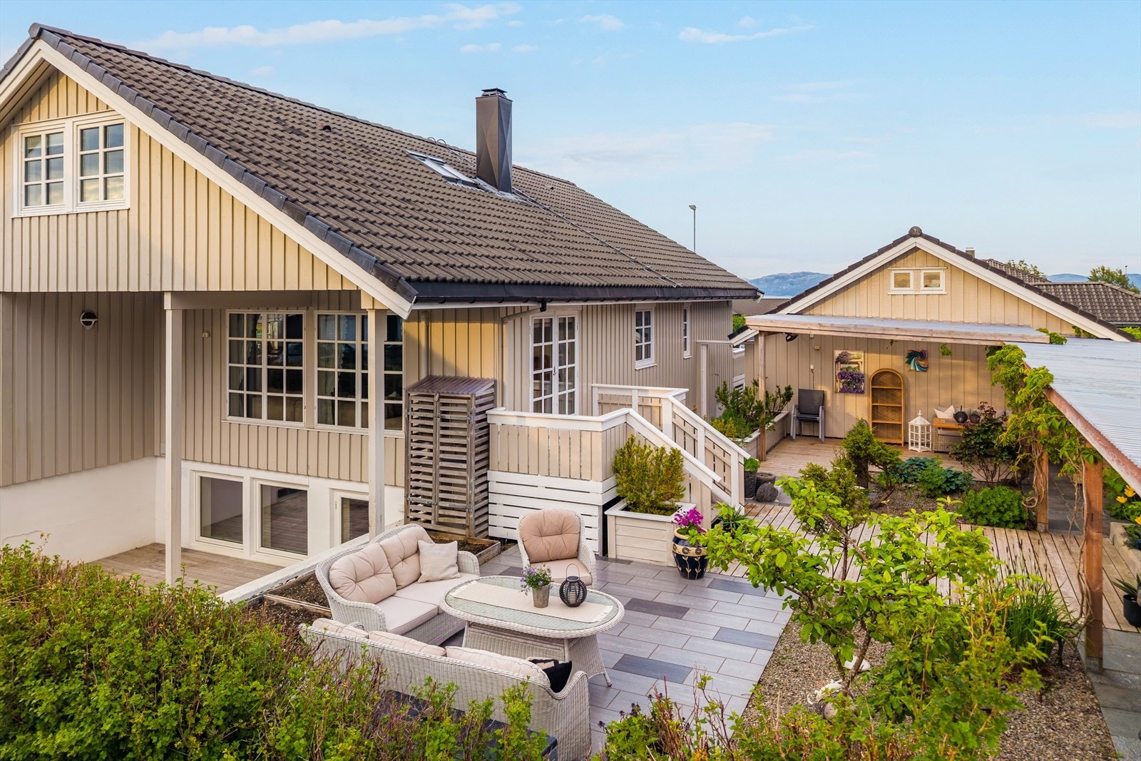 Innbydende uteområde med pent opparbeidet hage, terrasse og flere hyggelige sitteplasser. Galleribilde