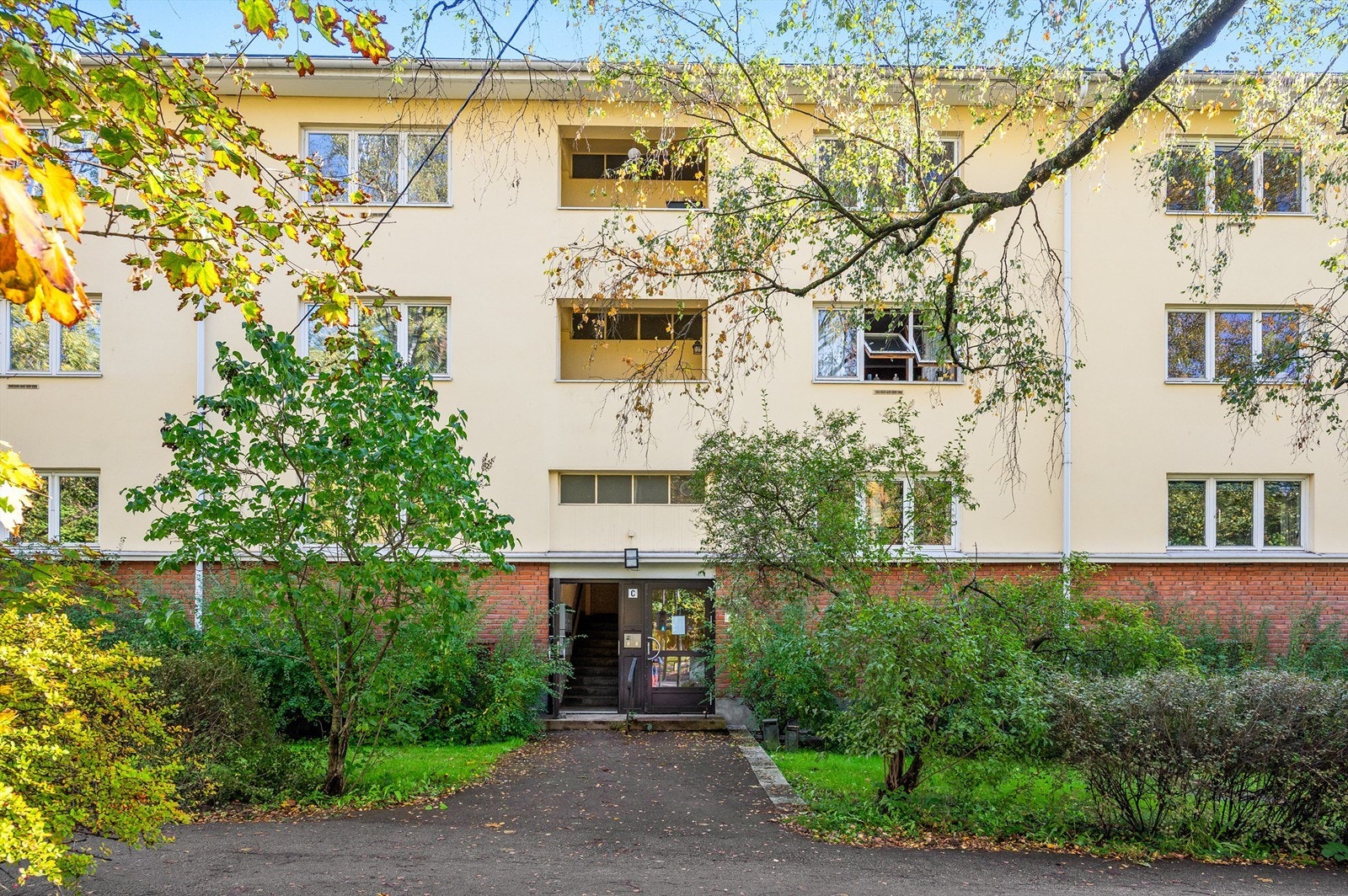 Leilighetens fasade med flotte grøntområder og adkomst via felles trappeoppgang. Galleribilde