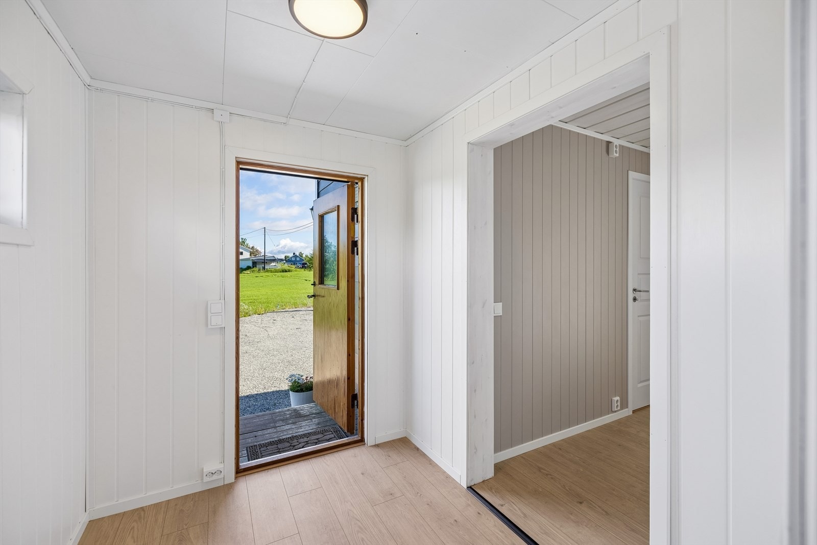 Velkommen inn! Inngangspartiet med vindfang er bygget i 1992 og leder inn i boligens første etasje. Galleribilde