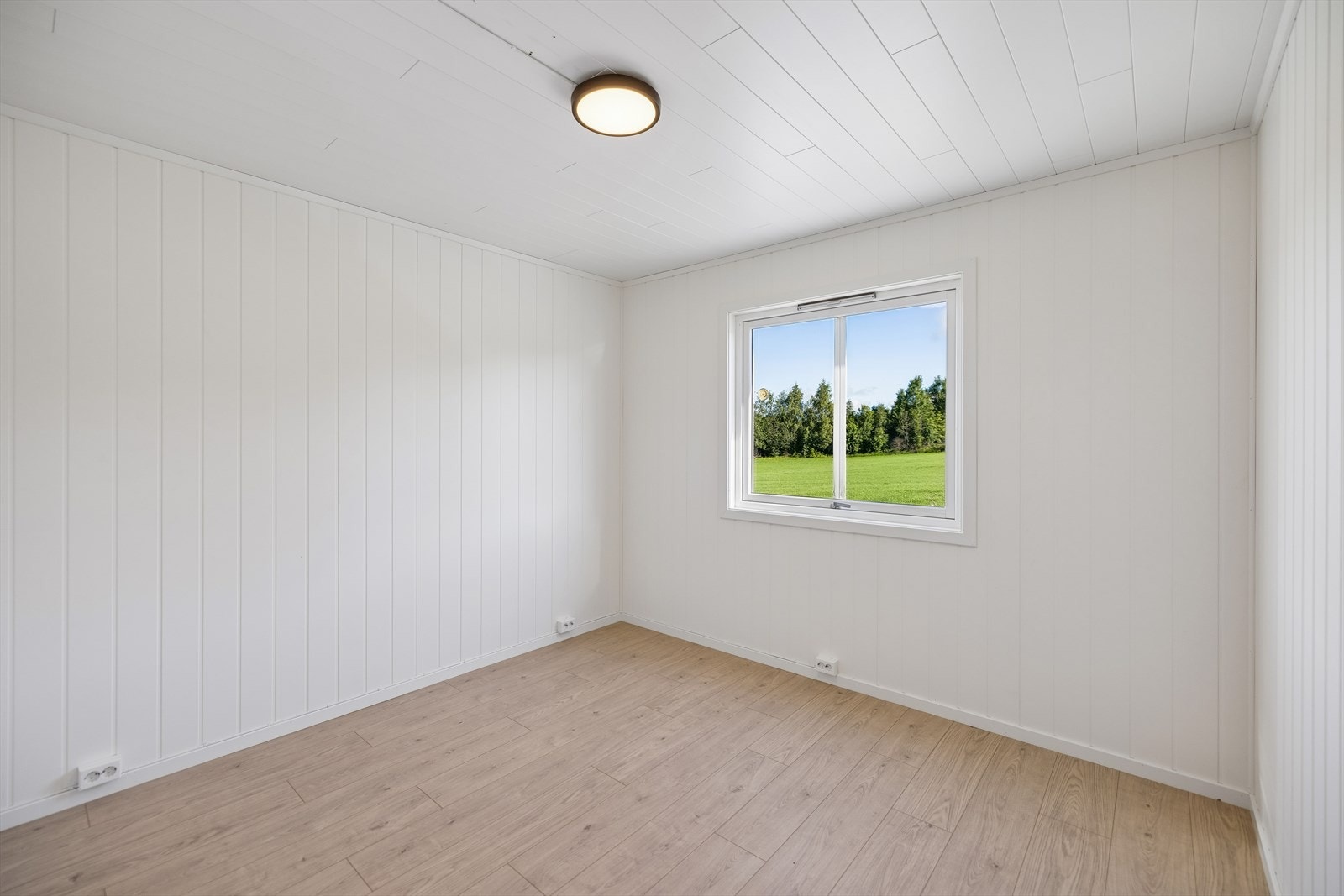 Soverom i første etasje med malte panelvegger og laminatgulv. Galleribilde