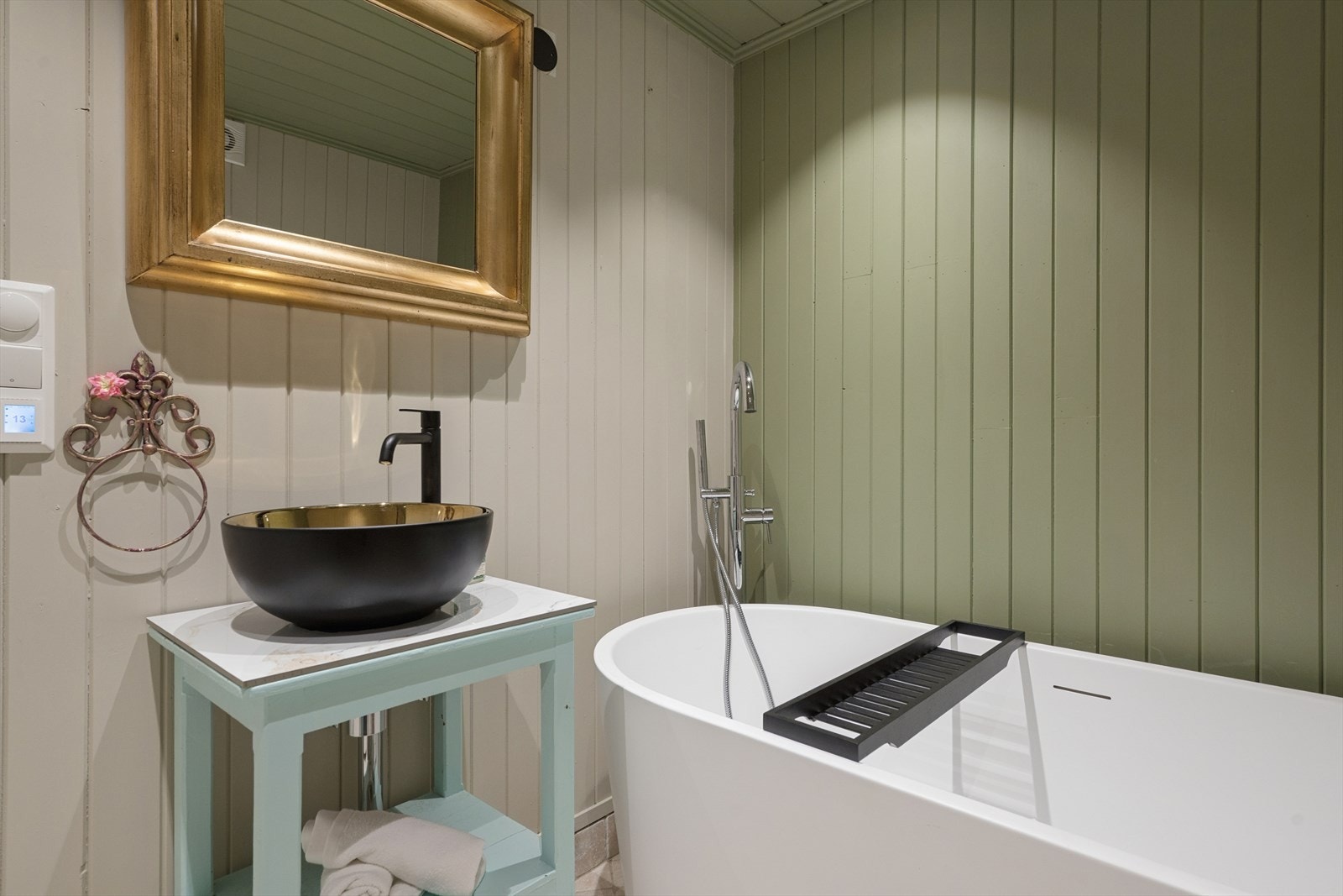 Badet har flislagt gulv med elektriske varmekabler og en stilren, ovenpåliggende servant. Galleribilde