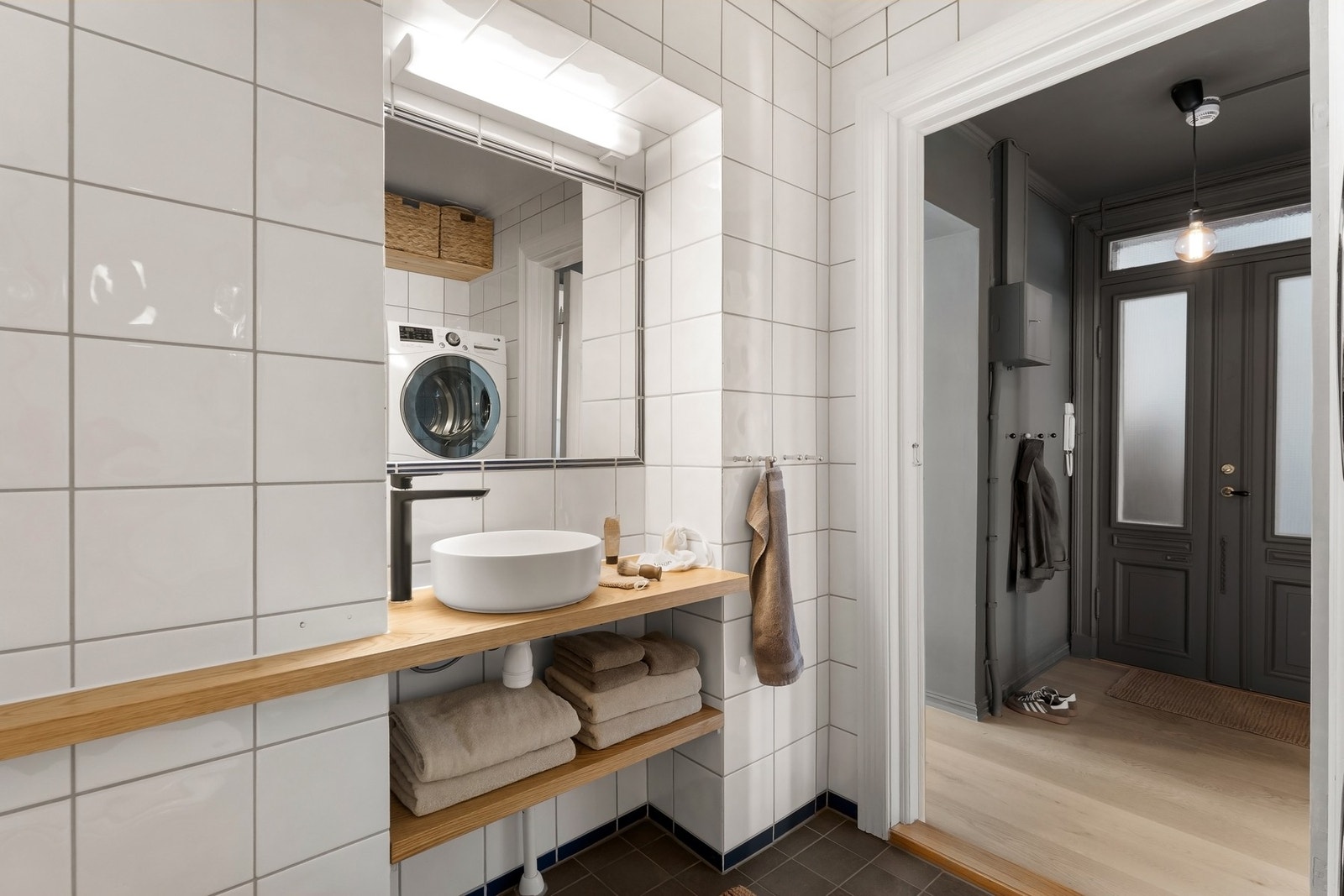 Badet har en praktisk planløsning med opplegg for vaskemaskin og tørketrommel, plassbygde hyller og speil innmurt i vegg over servant. Galleribilde