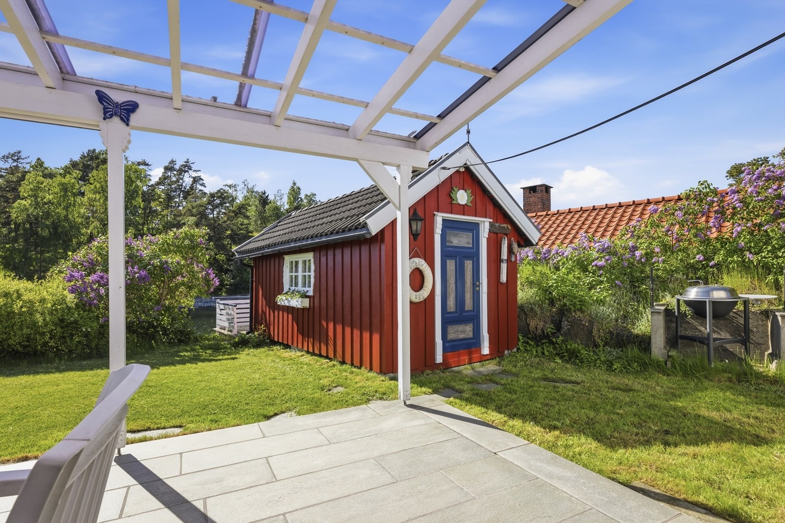 Den solide, skiferbelagte terrassen er et lunt og skjermet uterom. Galleribilde