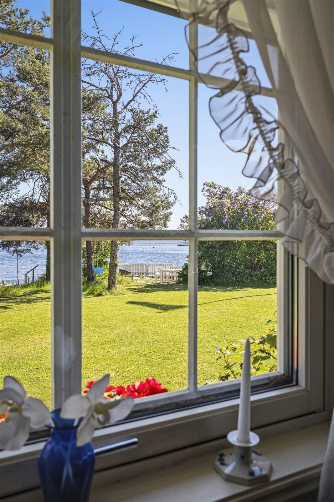 Vinduene rammer inn den naturskjønne utsikten mot hagen og fjorden. Galleribilde