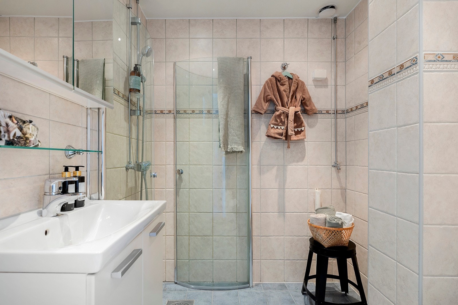 Romslig , flislagt bad med servant m/over- og underskap, dusjplass med innsvingbare dører av glass og wc. Galleribilde