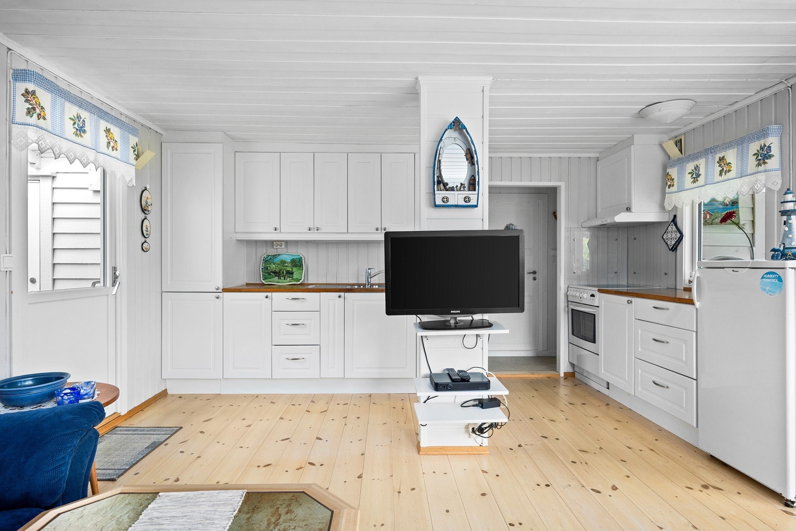 Kjøkkeninnredningen fra 2011 har hvite, profilerte fronter og benkeplate i heltre. Galleribilde