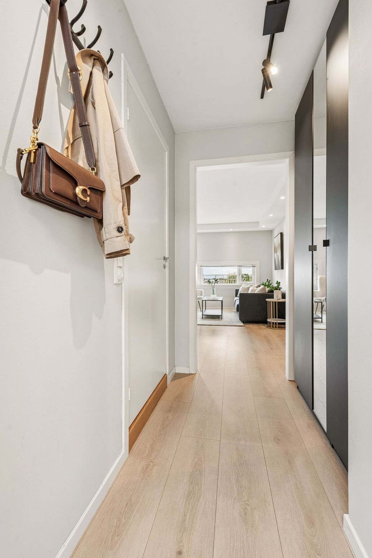 Innvendig møtes du av en lys og romslig entré som gir et hyggelig førsteinntrykk av boligen, med god plass til oppbevaring i stort garderobeskap i nisje i vegg. Galleribilde