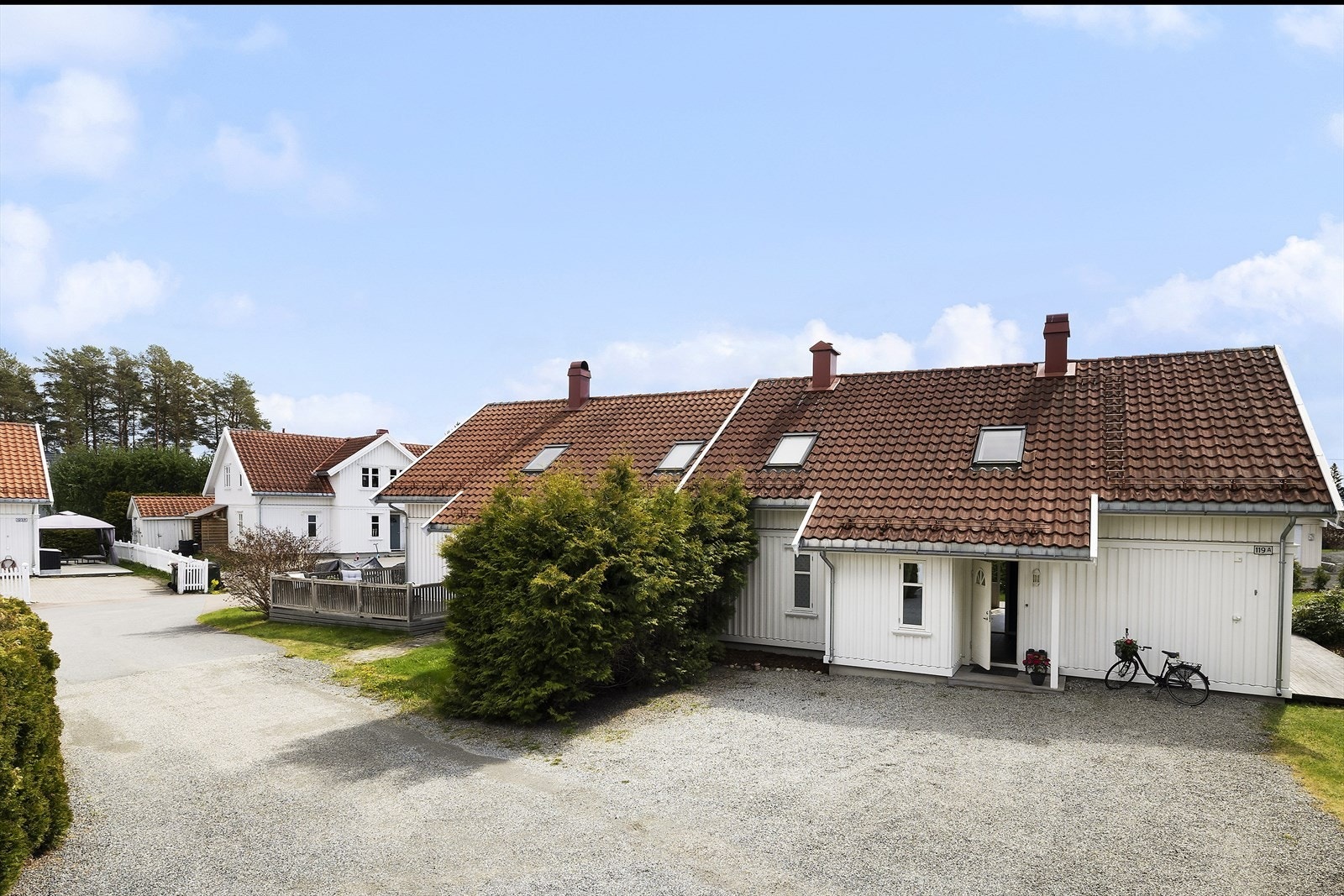 Gruset innkjørsel og gårdsplass med god plass til parkering. Galleribilde
