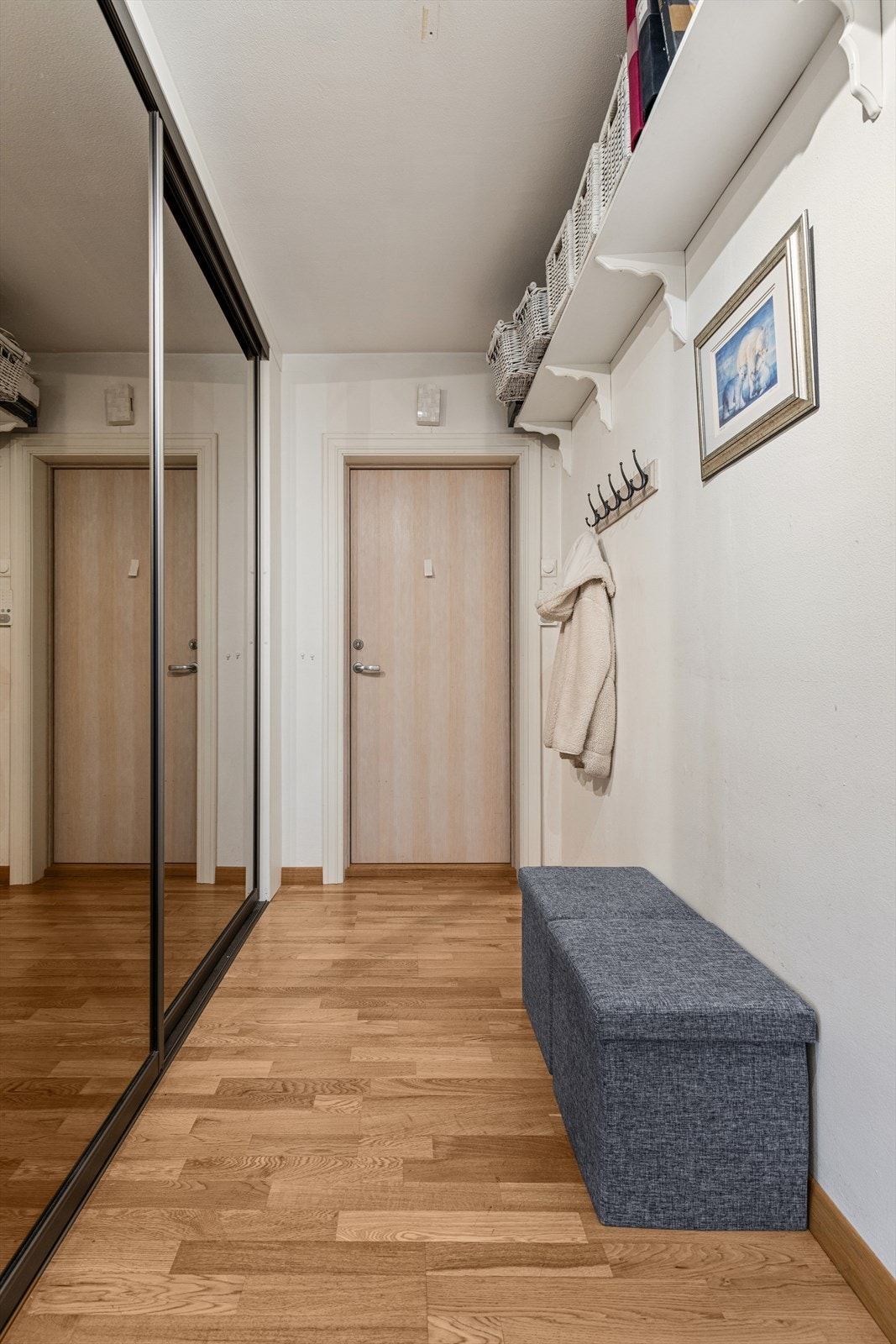 Romslig entré med en stor skyvedørsgarderobe for effektiv oppbevaring av yttertøy. Galleribilde