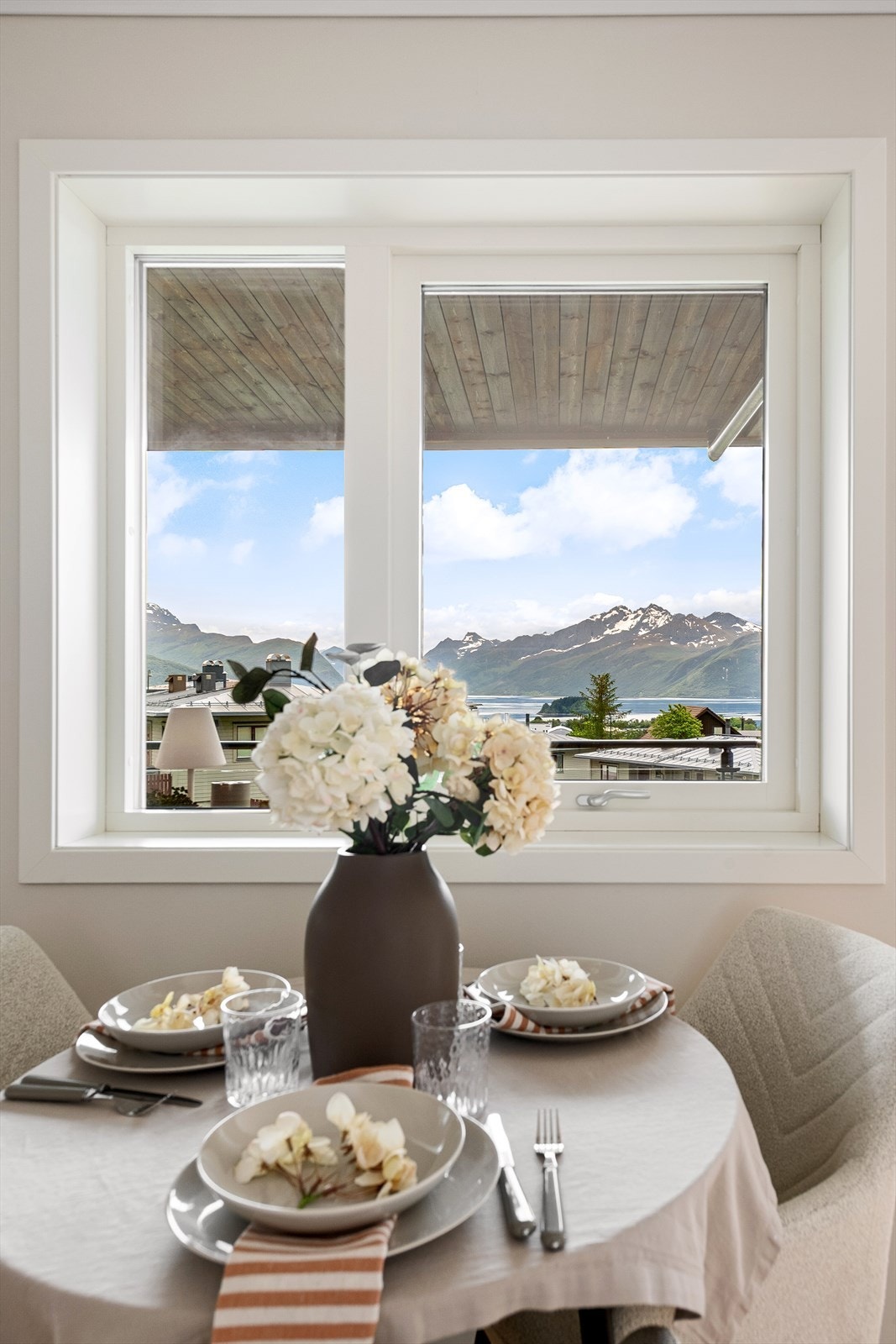 Spiseplassen ved kjøkkenvinduet rammer inn utsikten mot fjell og fjord. Galleribilde