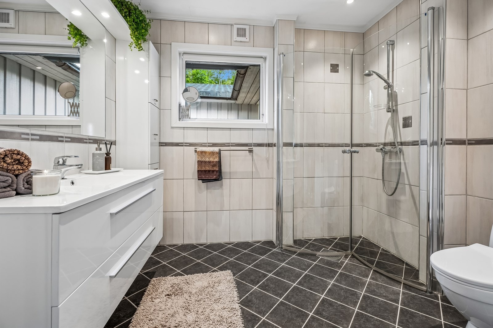 Badet i første etasje ble oppgradert i 2013 med fliser, ny innredning og dusjhjørne med buede glassdører. Galleribilde