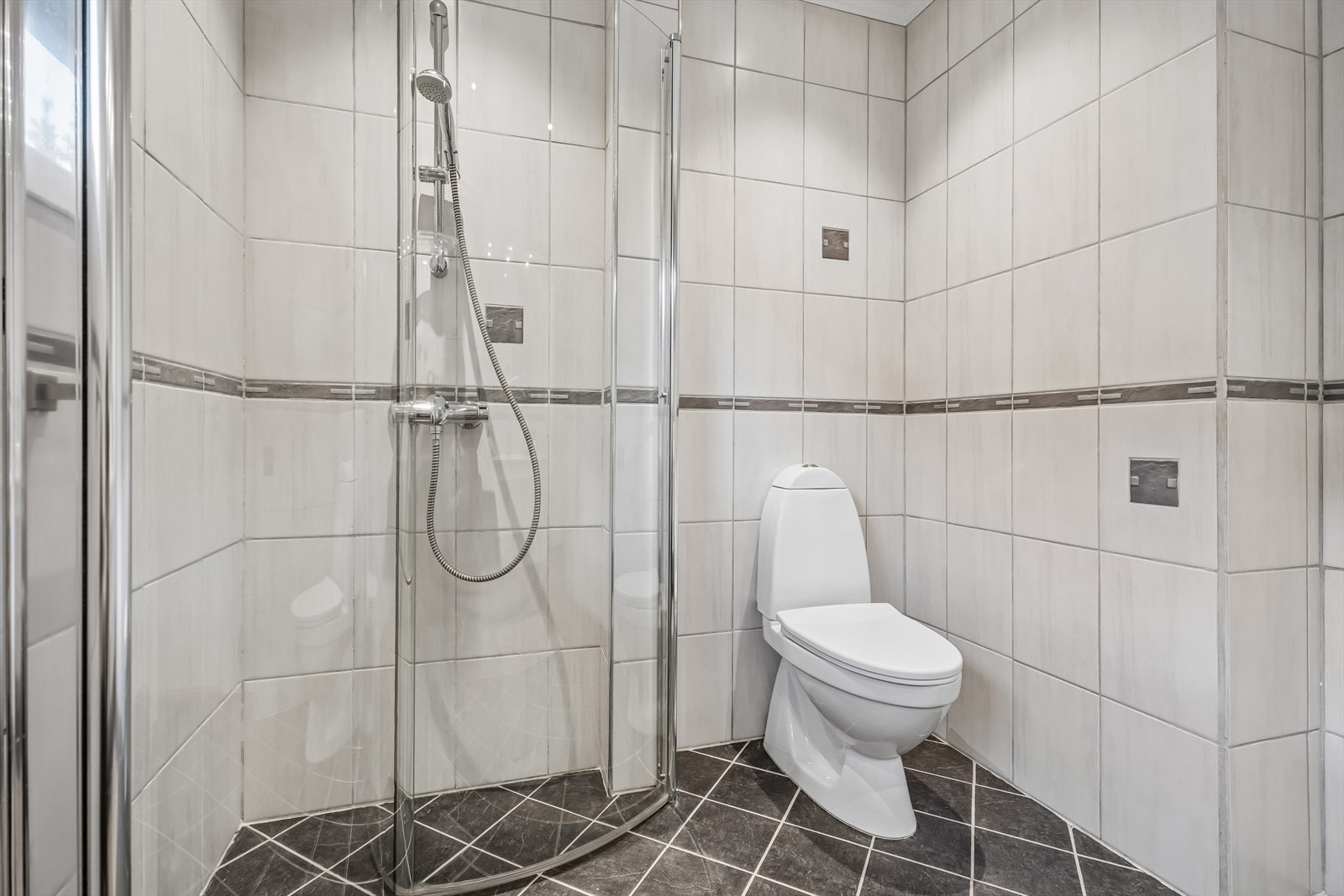 Badet har mekanisk avtrekk og et gulvmontert toalett. Galleribilde