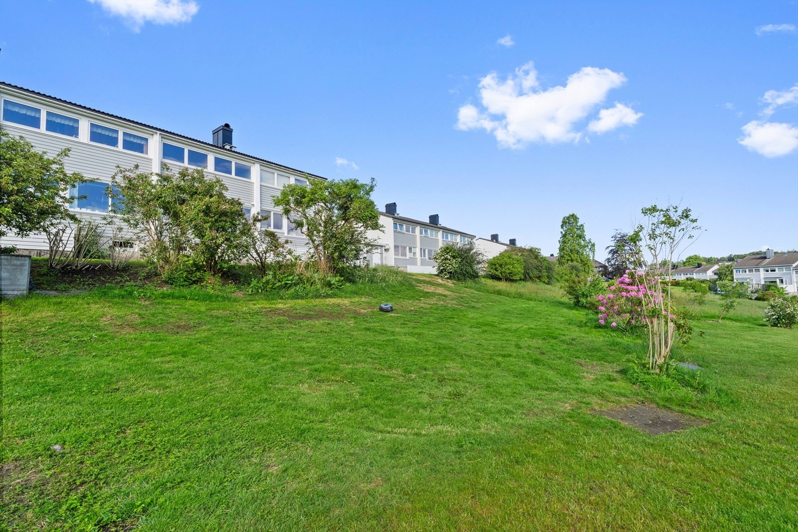 Borettslaget er velholdt og pent opparbeidet med grønne plenarealer, hekk, blomster, dekorative planter og belagte steinområder Galleribilde
