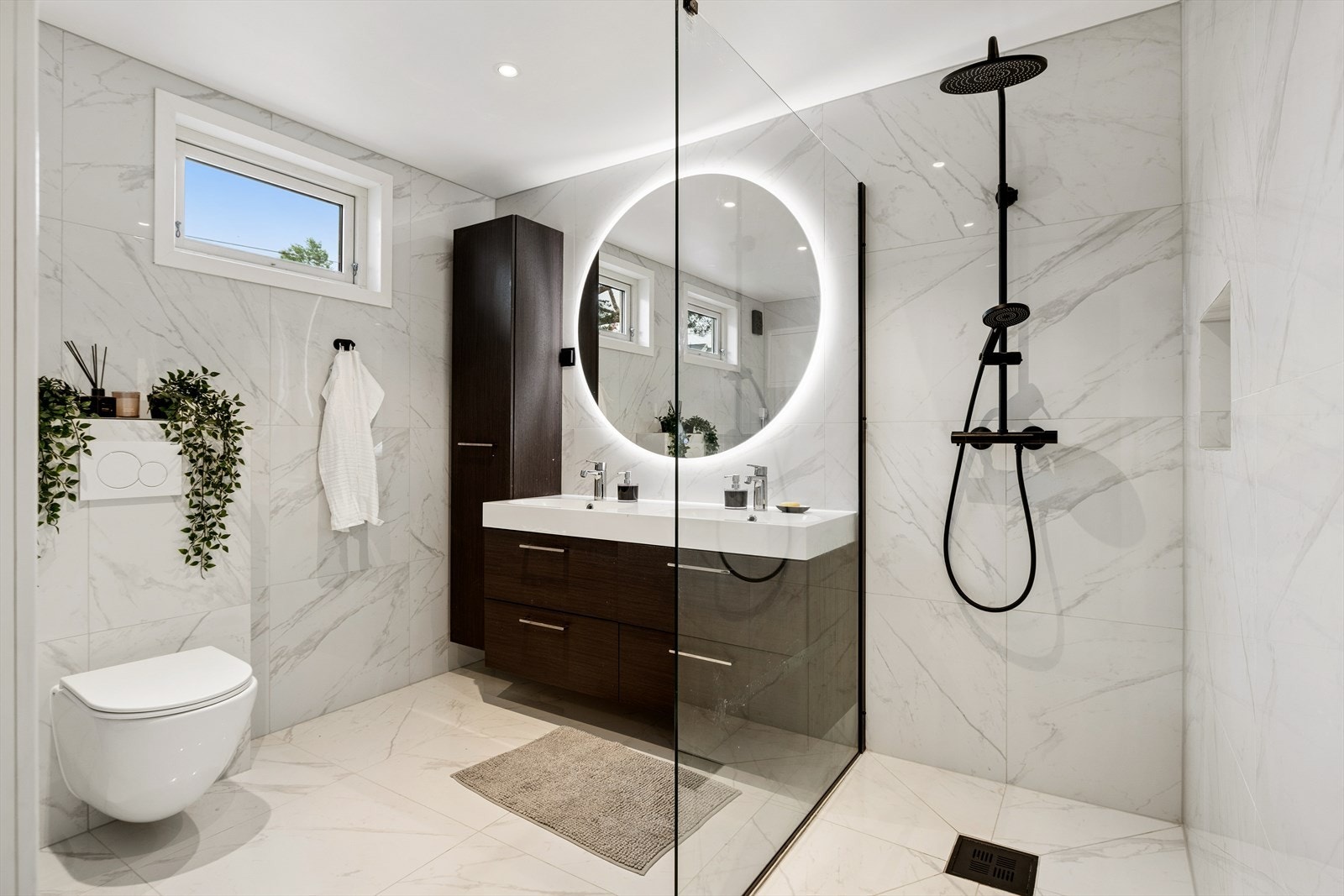 Badet har vegghengt toalett og en romslig dusjnisje med glassvegg. Galleribilde