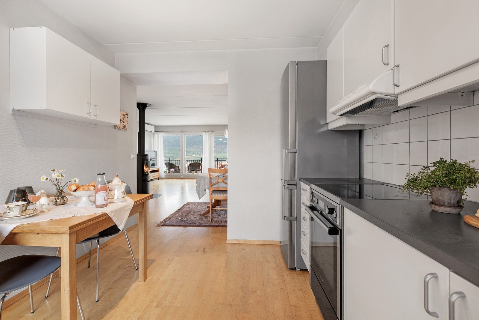 Pent kjøkken med innredning med lyse fronter, gode arbeidsflater og rikelig med oppbevaringsplass. Galleribilde