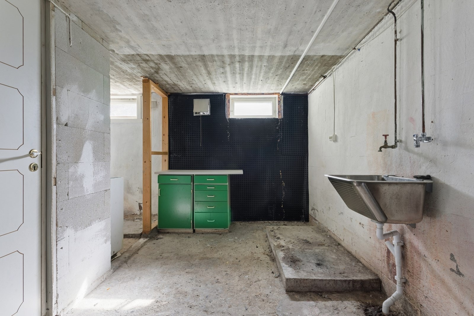 Praktisk vaskerom i kjeller med opplegg for vaskemaskin og god plass til daglige gjøremål. Vaskerom med utviklingspotensial for deg som ønsker å modernisere og sette ditt eget preg. Galleribilde
