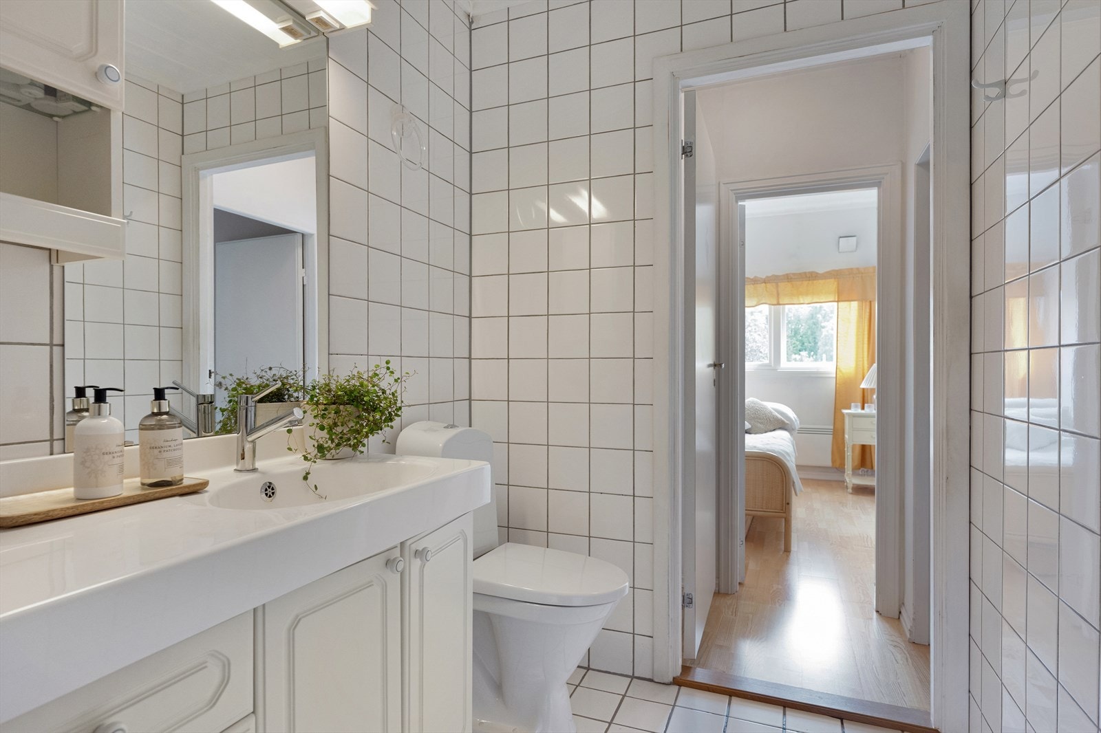 Badet er innredet med dusjhjørne med skyvedører og kabinettsokkel, servant i innredning med skuffer og skap, speil på vegg samt toalett Galleribilde