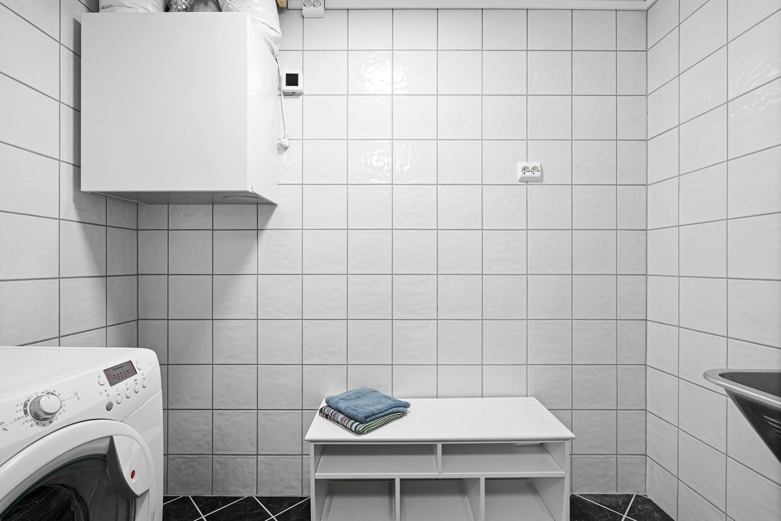 Badet har et dedikert område for vaskemaskinen og eventuelle ekstra lagrings og- oppbevaringsmuligheter. Galleribilde