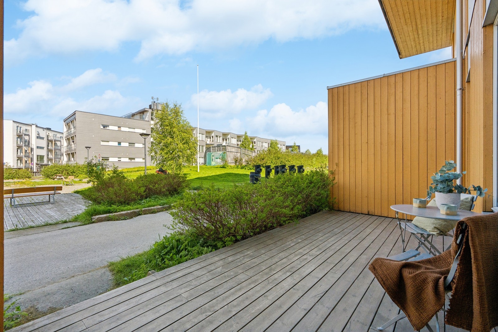 Terrassen ved inngangen har impregnert tregulv og vender ut mot borettslagets fellesarealer. Galleribilde