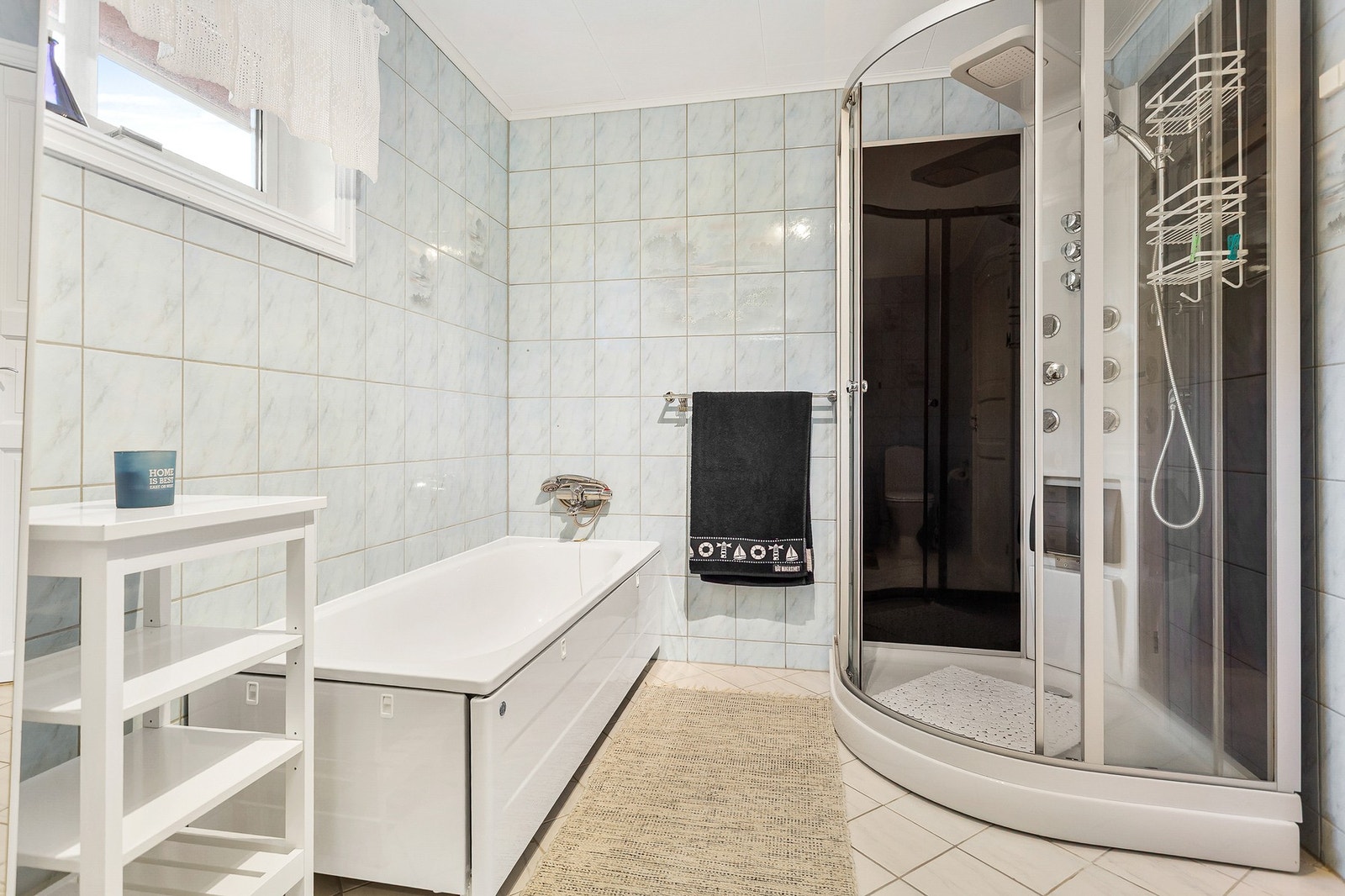 Badet er utstyrt med dusjkabinett, badekar, toalett og servantskap. Galleribilde