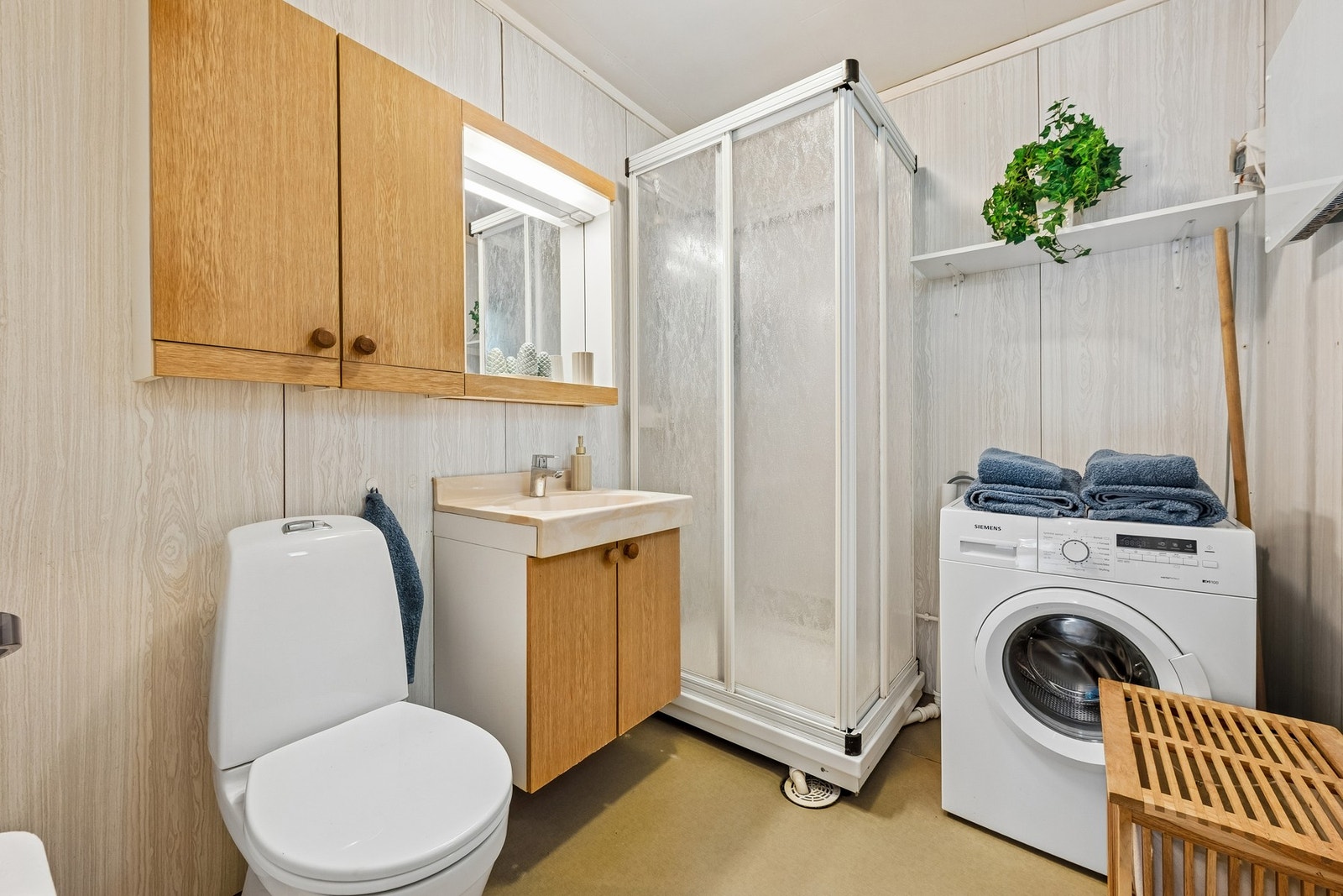 Bad i hovedetasje innredet med servant, dusjkabinett, wc og vaskemaskin. Galleribilde