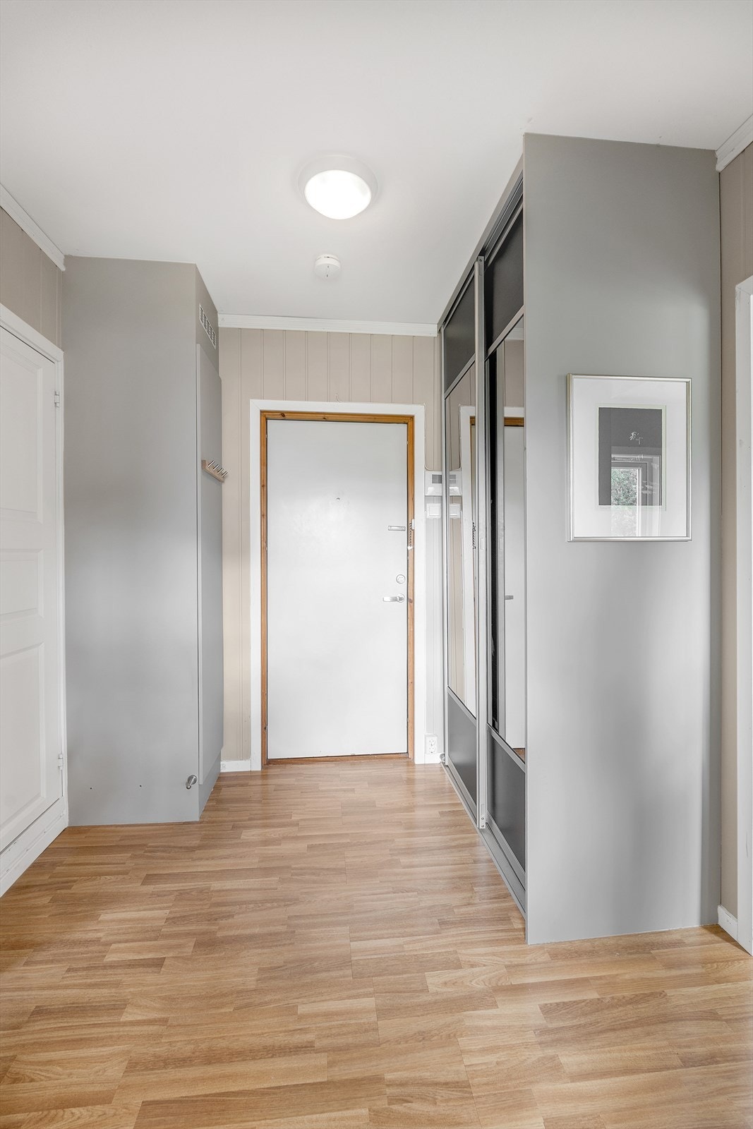 Romslig entré innredet med praktisk skyvedørsgarderobe for oppheng og lagring av både yttertøy og sko. Galleribilde