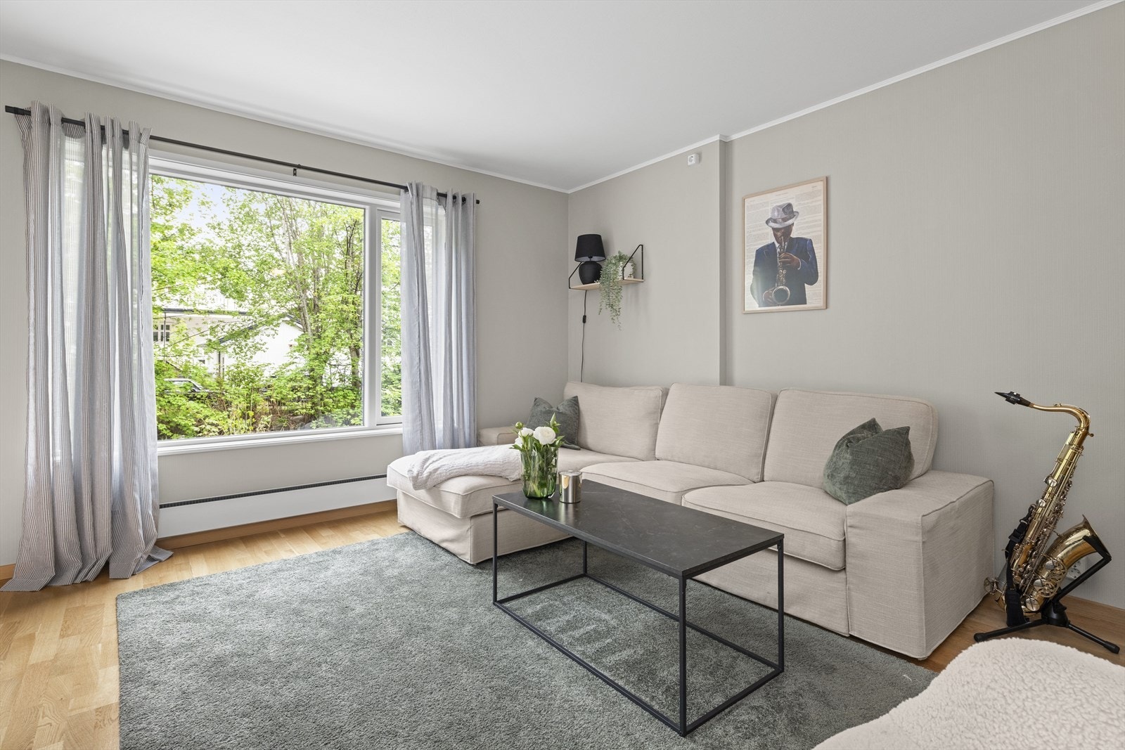 Lys og fin stue som er malt med en farge som skaper et stilrent og tidsriktig preg Galleribilde