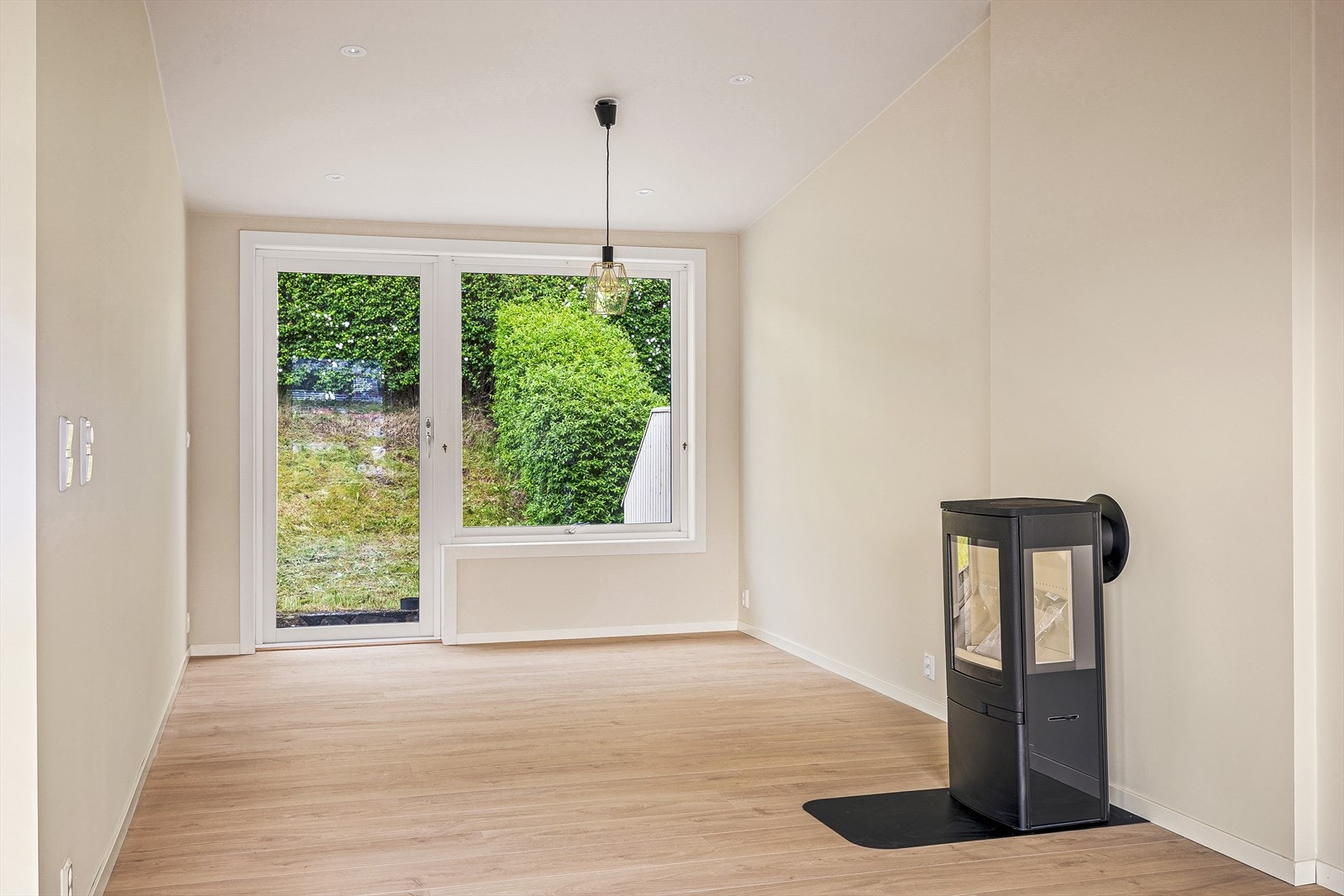 Stuen har en ny og moderne peis som tilfører boligen både varme, atmosfære og et elegant blikkfang. Galleribilde