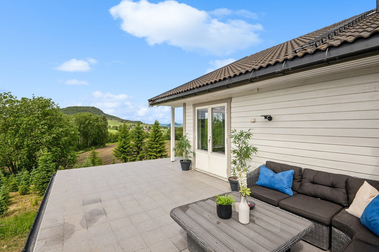 Fra stuen er det utgang til en stor terrasse som strekker seg langs store deler av huset. Det mangler rekkverk på terrassen. Dette bør settes opp med tanke på sikkerhet. Galleribilde