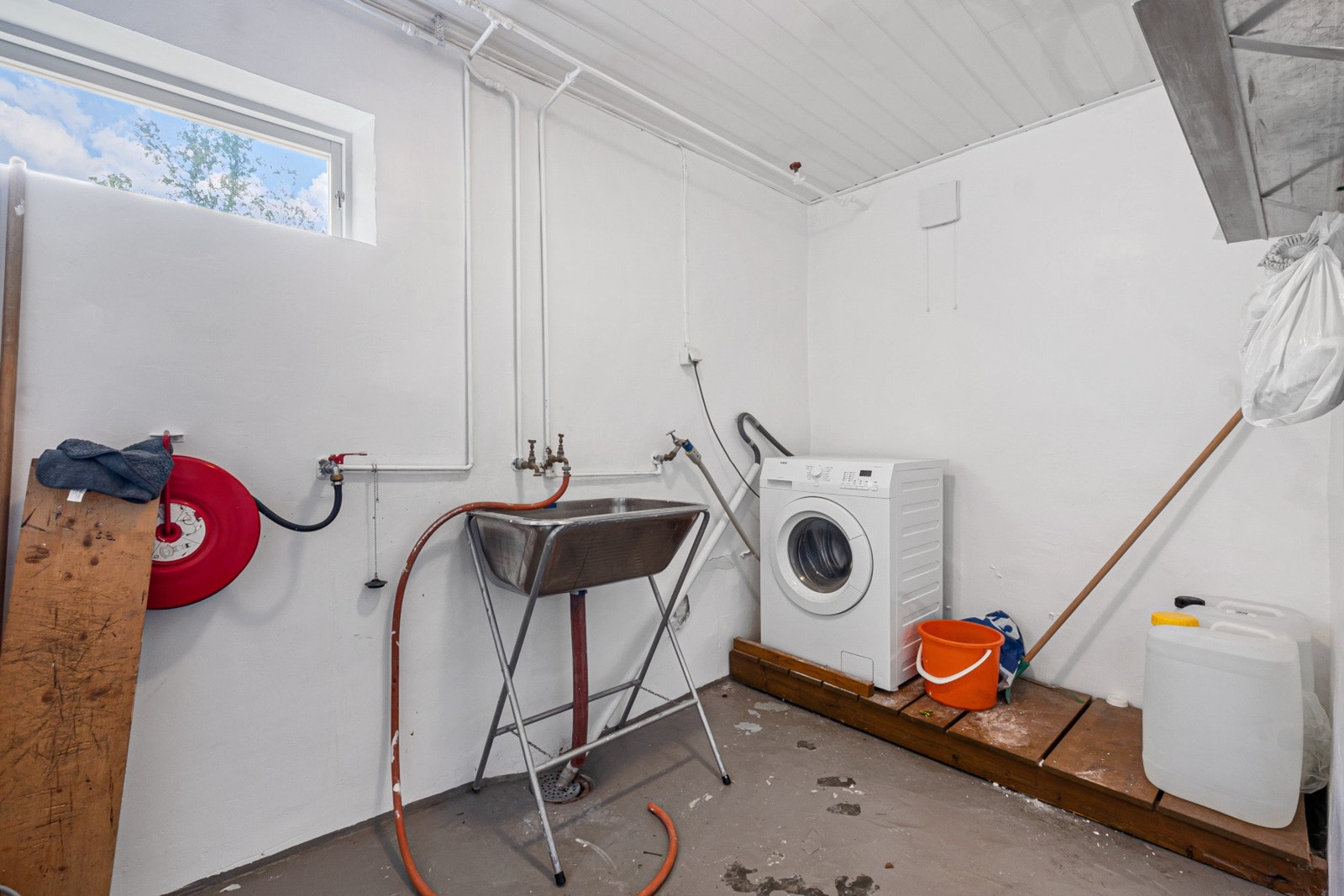 Praktisk vaskerom i kjeller med opplegg for vaskemaskin og utslagsvask. Galleribilde