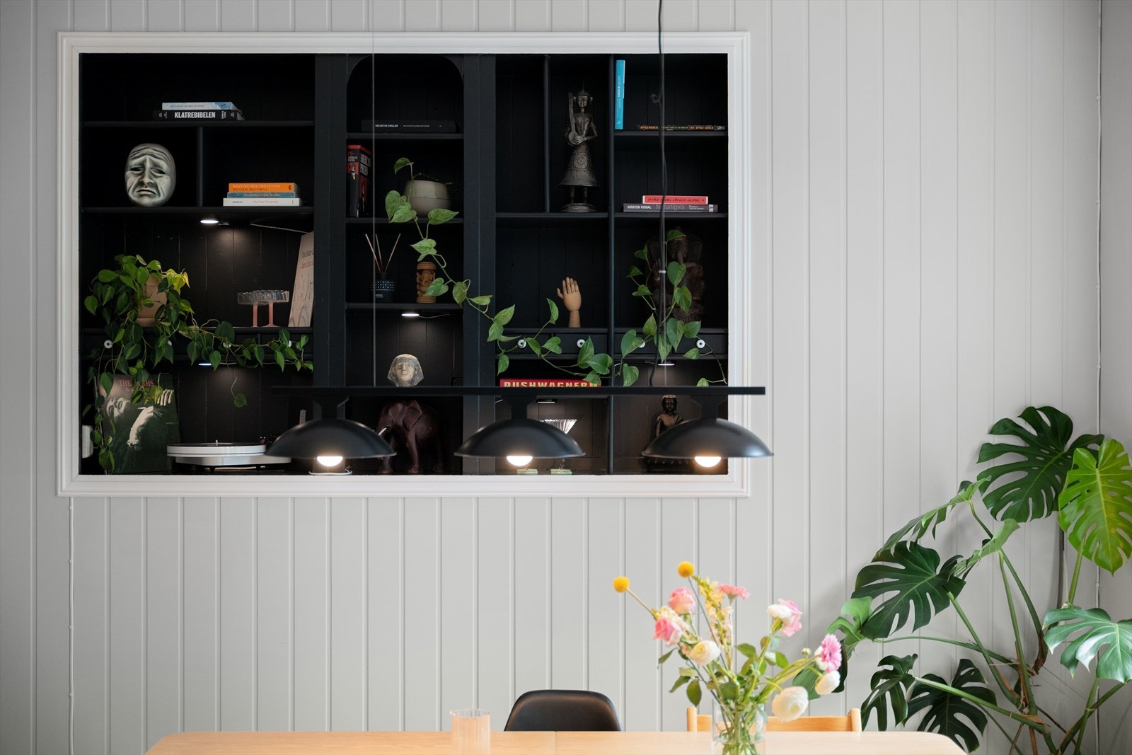 Stuen får et særegent uttrykk med den gamle utstillingshyllen fra Christiania Glasmagasin - et dekorativt element som tilfører både historie og personlighet til rommet. Galleribilde