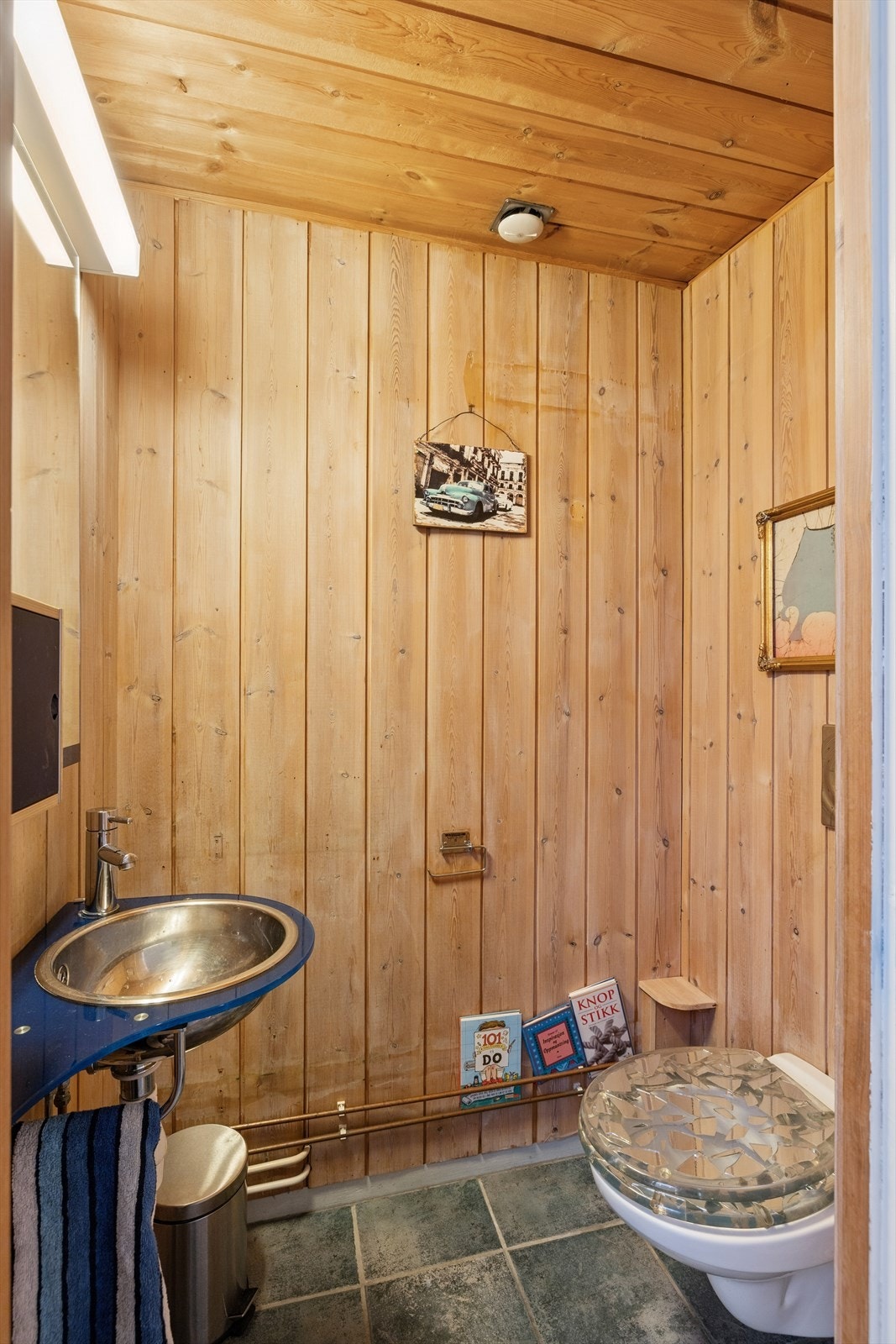 Toalettrom nr. 2 i boligens 1. etasje har fliser og panel på veggene, og panel i tak. Rommet er utstyrt med vask, speil og vegghengt toalett. Galleribilde