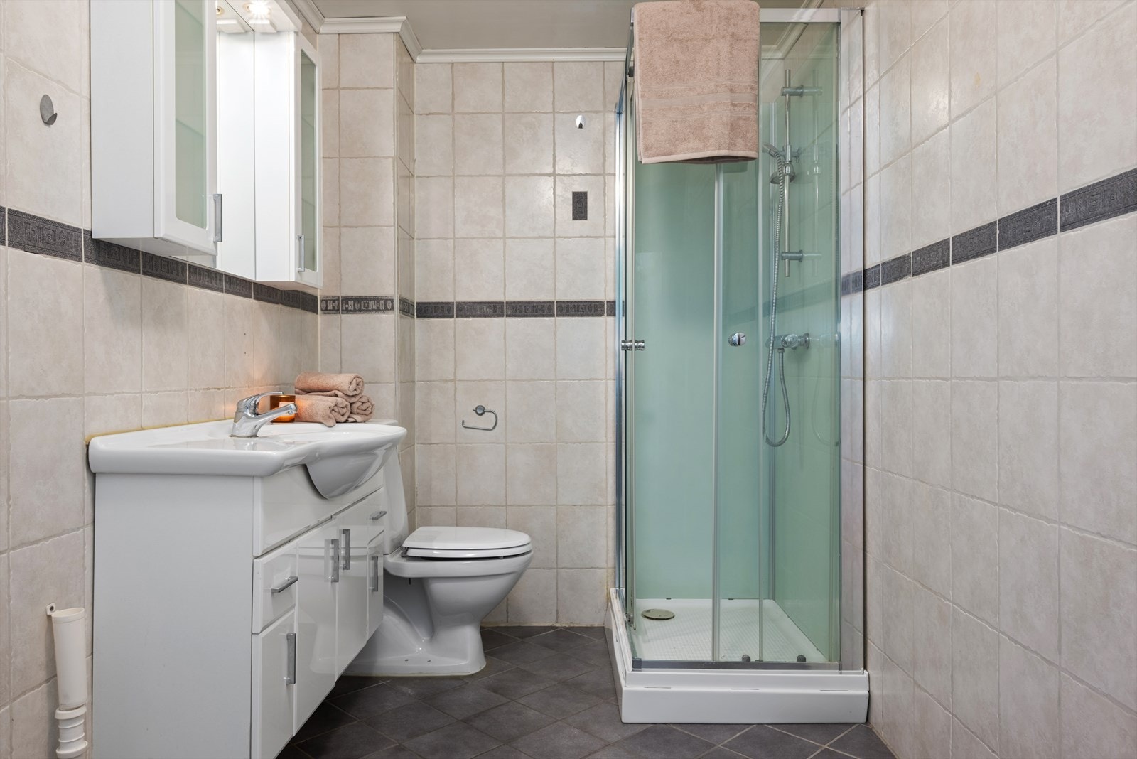 Utleiedelen har et smart innredet bad på 6,5 kvm. Badet er utstyrt med dusjkabinett, servantskap, wc og opplegg for vaskemaskin. Galleribilde