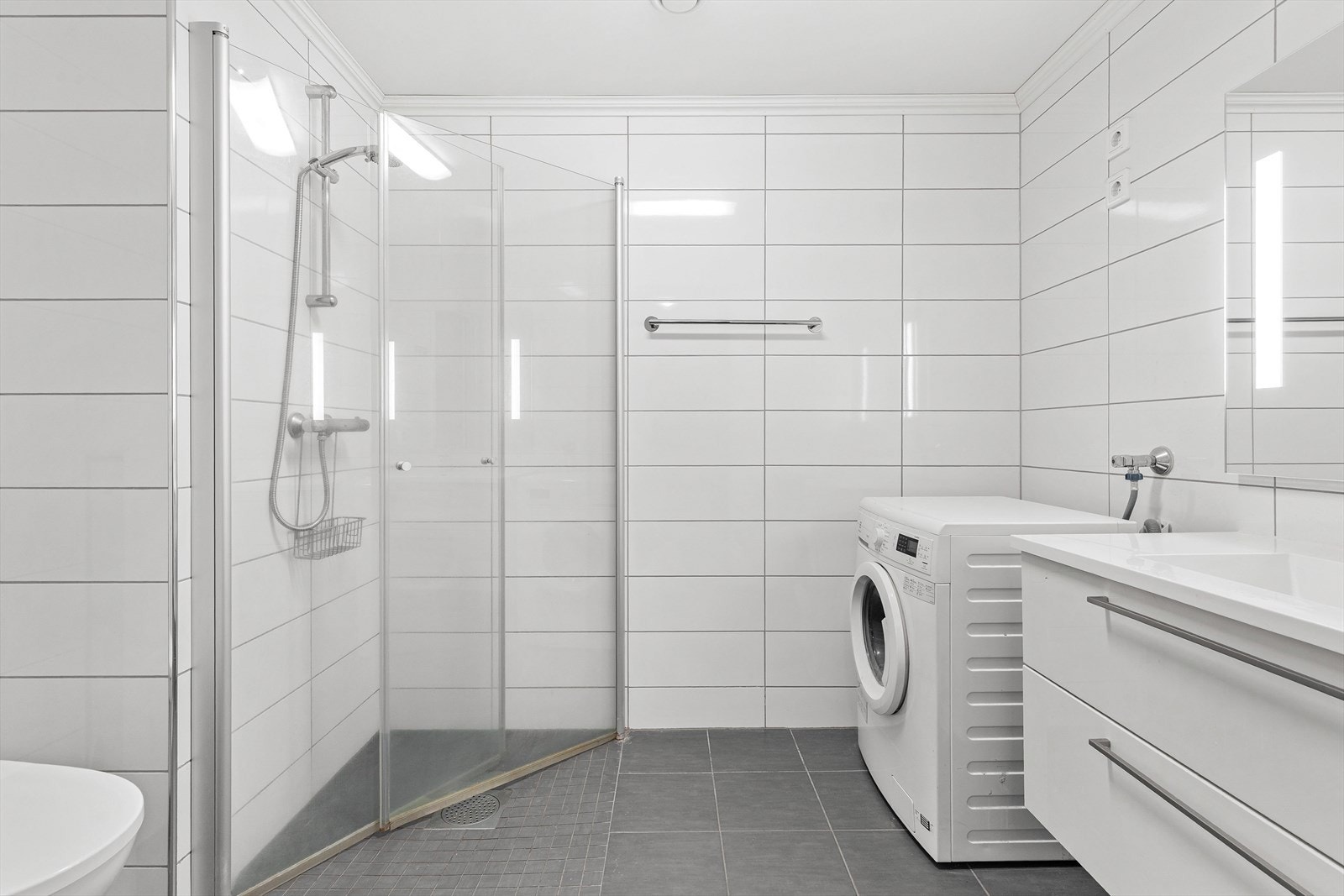 Pent, flislagt baderom med varme i gulvet og opplegg for vaskemaskin. Galleribilde