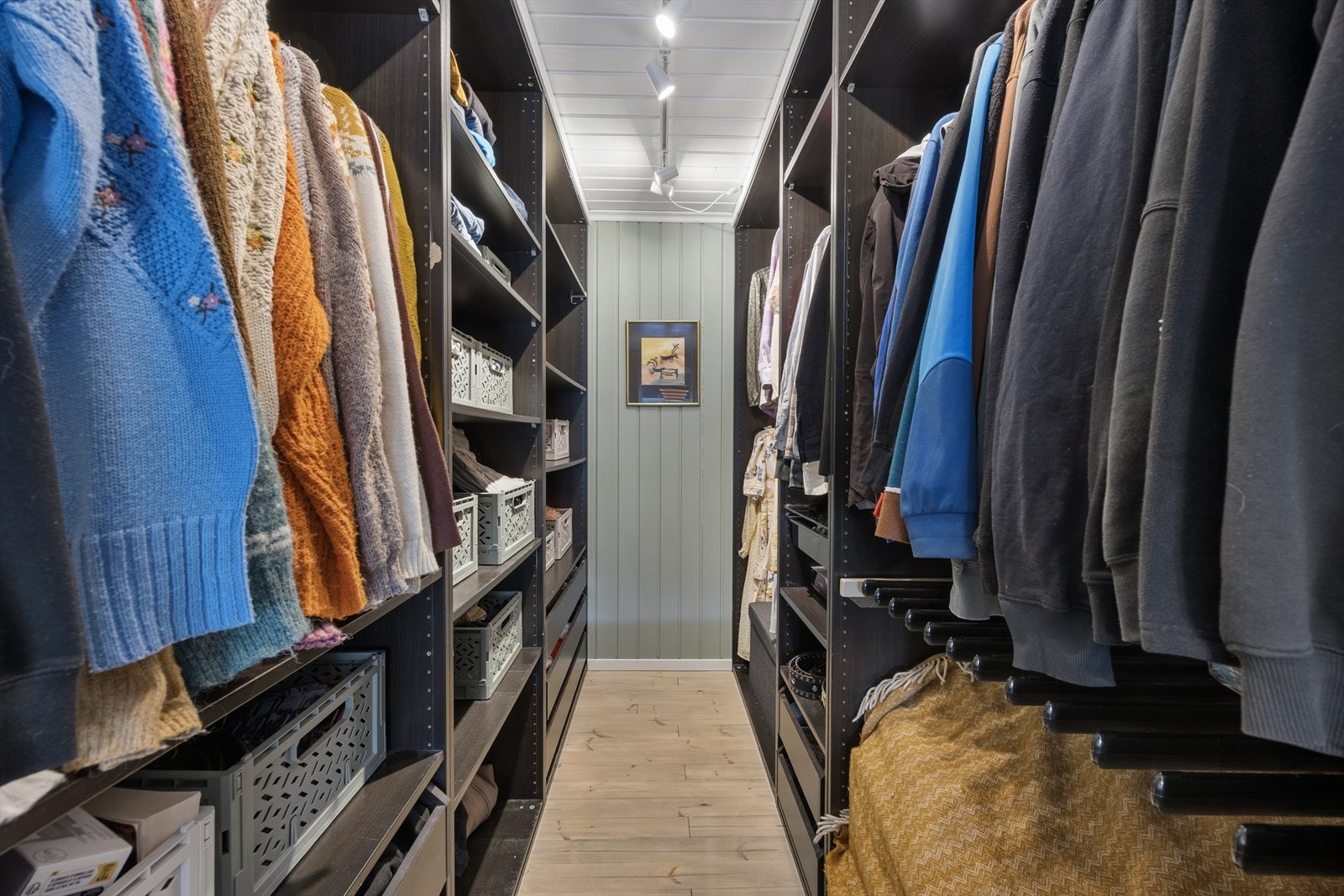 Praktisk innredet walk-in closet med rikelig hylle- og hengeplass. Galleribilde
