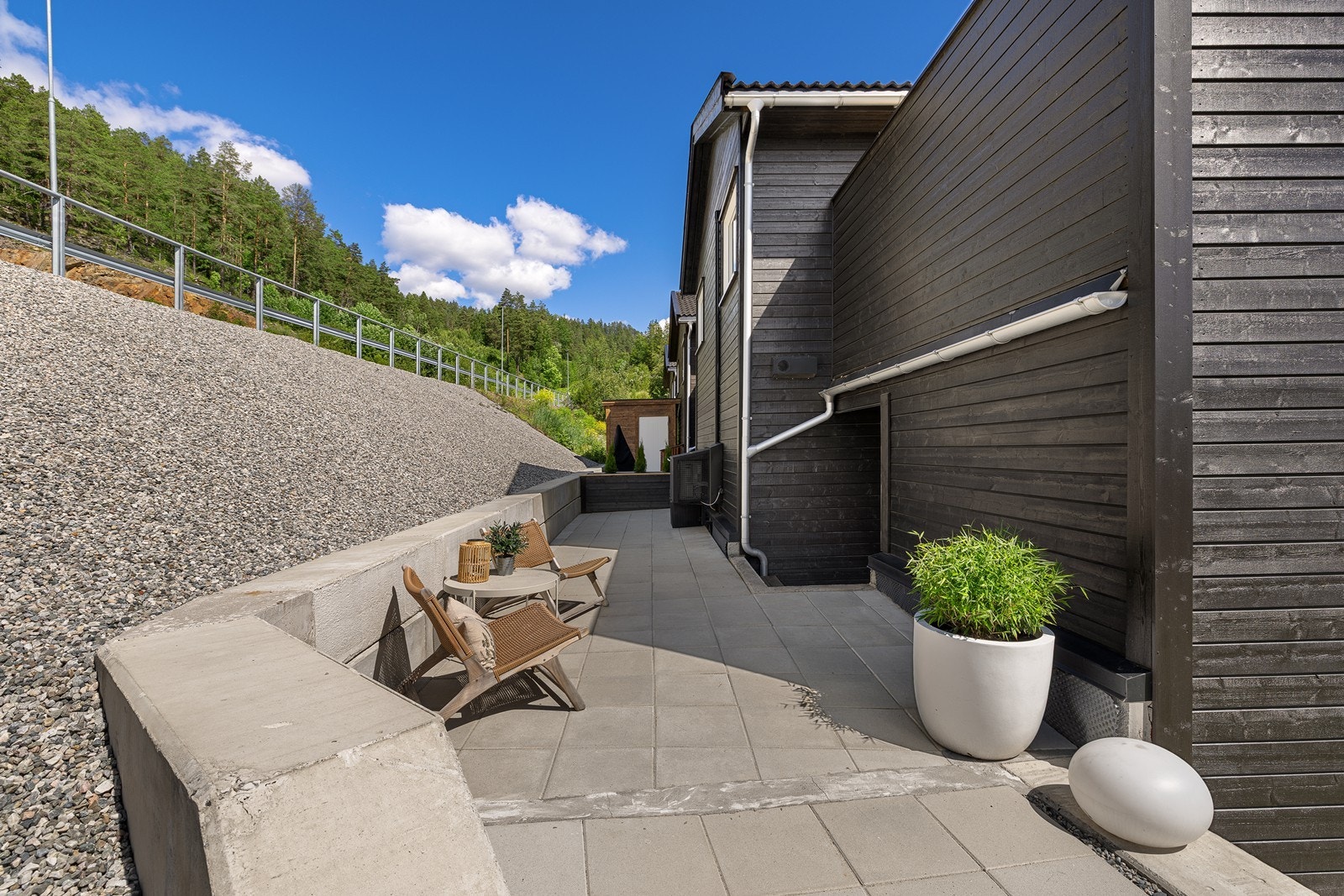 Forstøtningsmurer i betongstein rammer inn uteområdene på en solid måte. Galleribilde