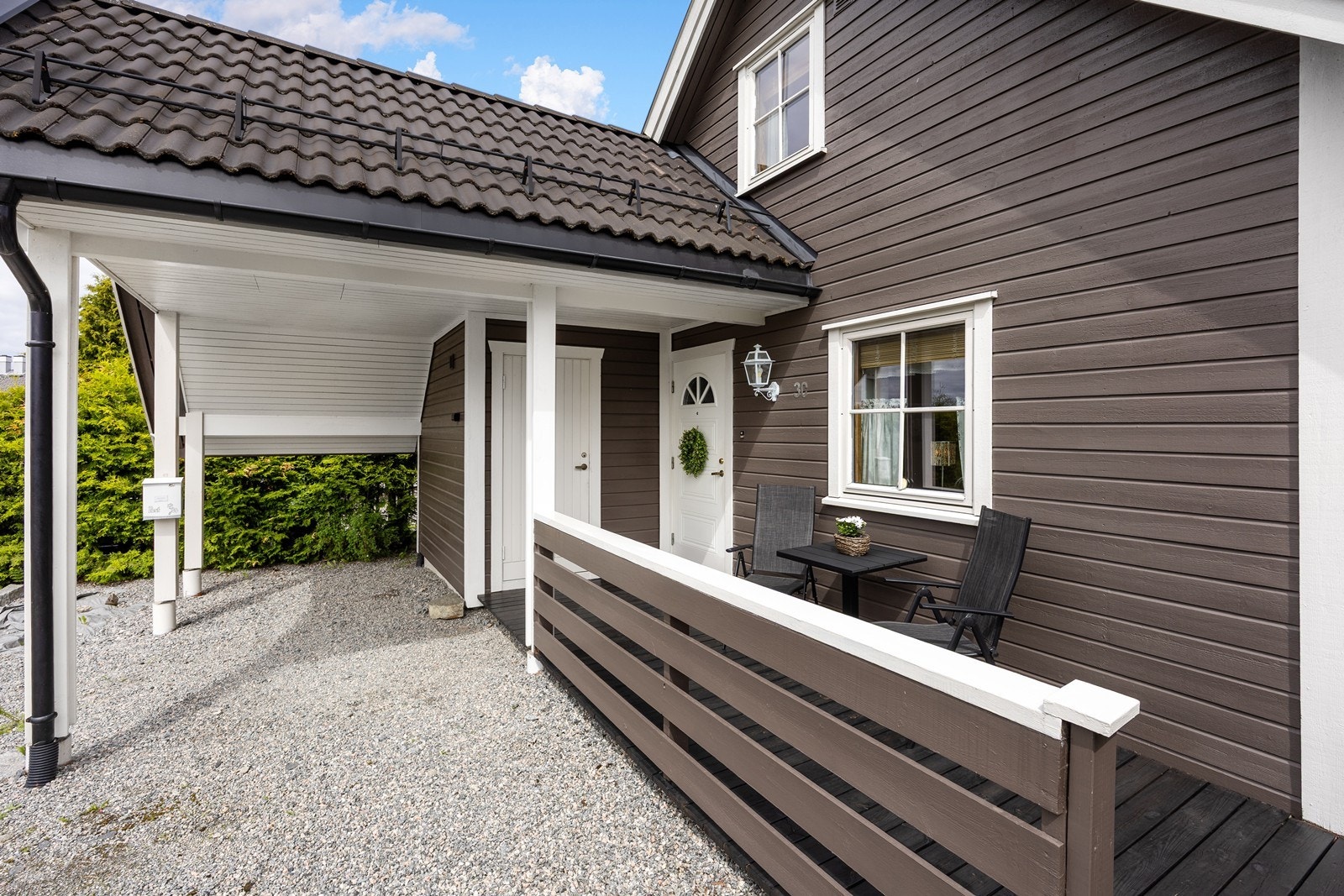 Eneboligen har en carport ved inngangen. Carporten er en del av en singlet gårdsplass med mulighet for ytterligere parkering. Galleribilde
