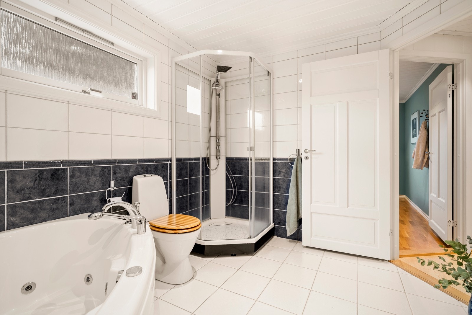 Videre til badet i 1. etasje, et bad som fremstår lyst og funksjonelt, med dusj, badekar og praktiske løsninger. Galleribilde