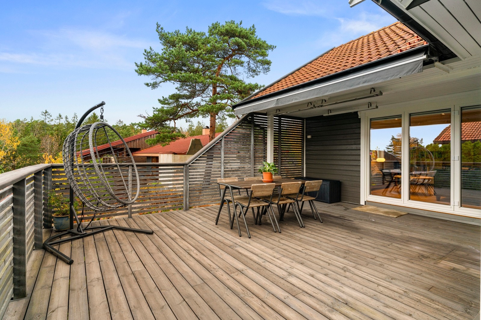 Terrassen i 1. etasje strekker seg langs boligen og gir god plass til flere soner med utemøbler. Her er det rom for både spisegruppe, grill og sittegrupper. Galleribilde