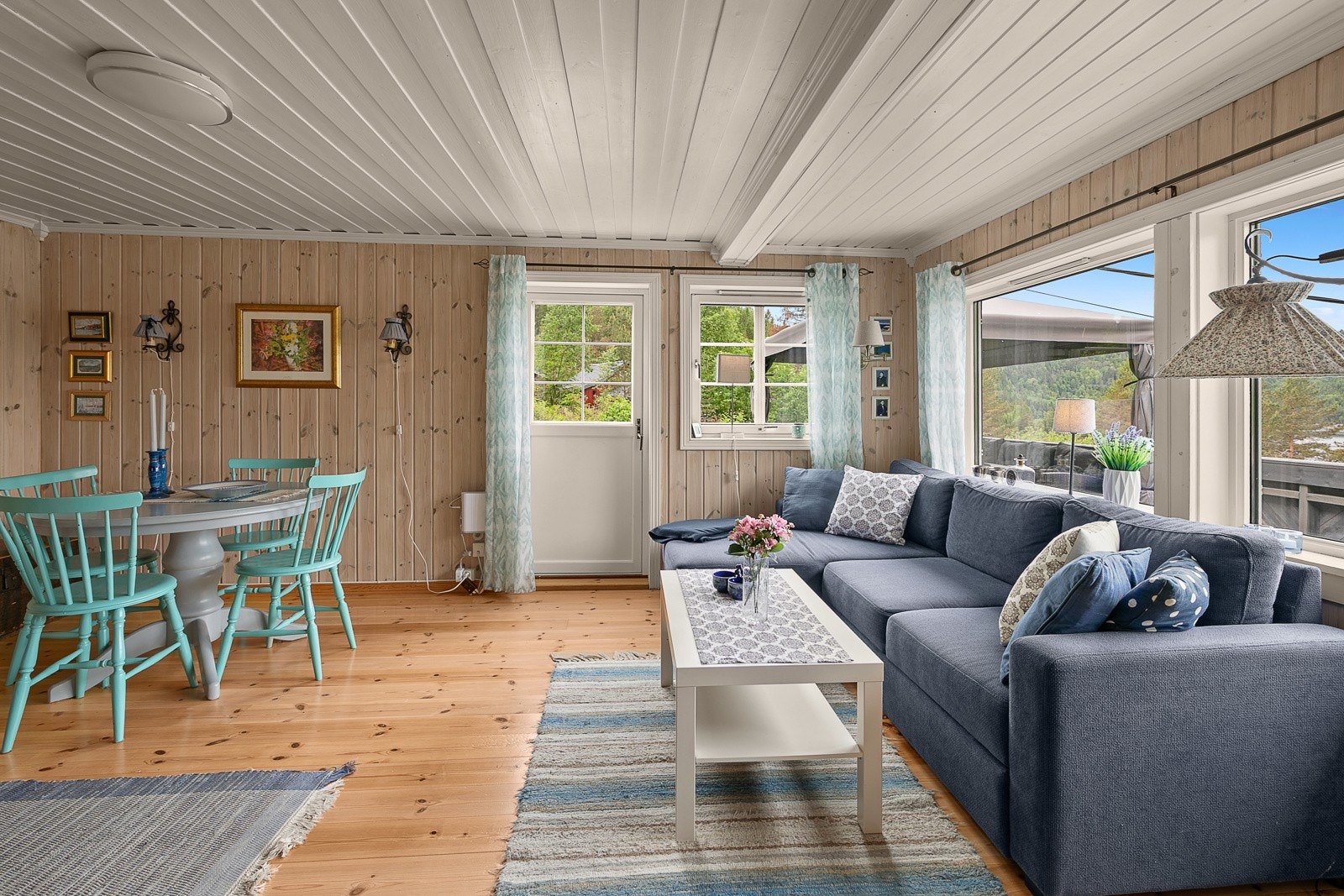 Det er plass til både sofa og spisestuemøblement i stuen og dør rett ut til verandaen. Galleribilde