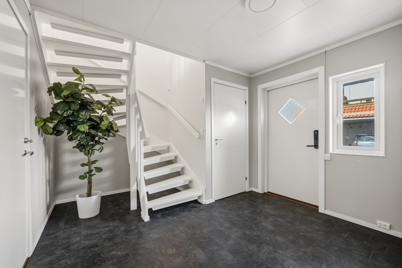 Entréen i første etasje har en malt tretrapp som leder opp til andre etasje. Galleribilde