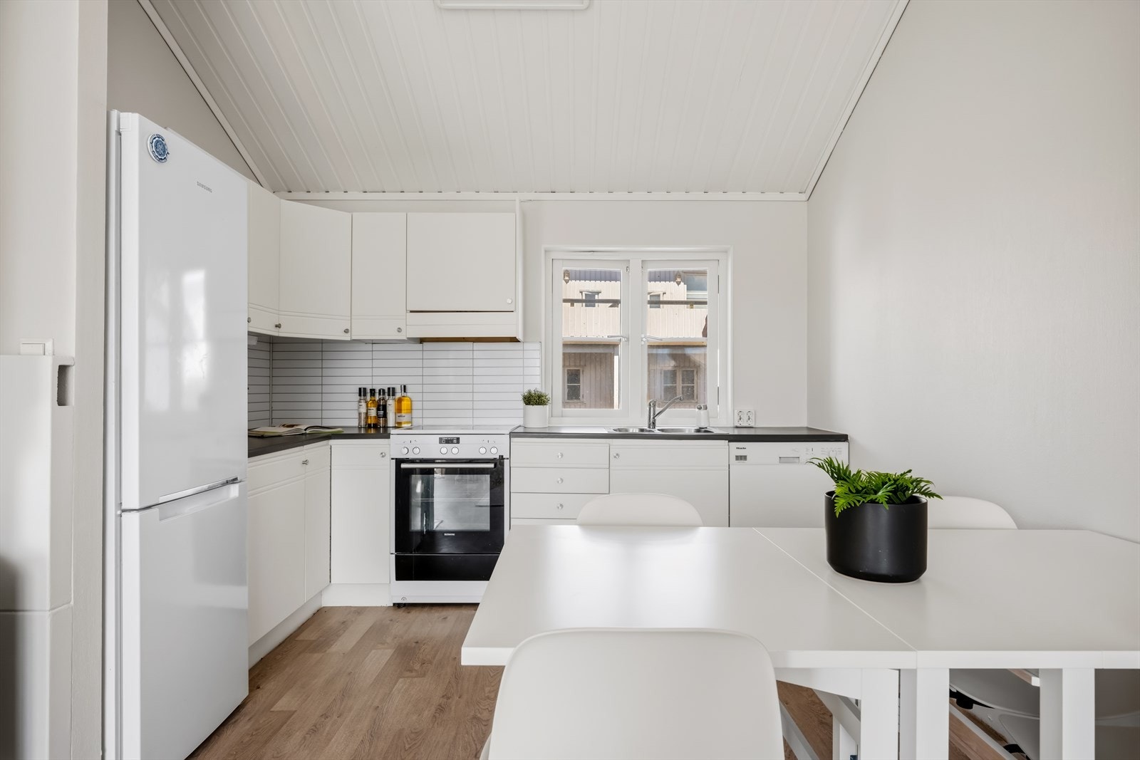Kjøkkeninnredning med profilerte fronter og benkeplate av laminat. Galleribilde