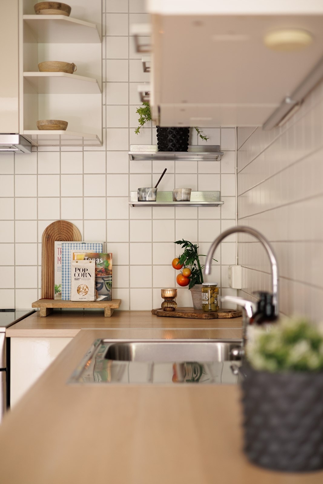 Innredningen har glatte fronter som gir et rent og moderne uttrykk, kombinert med fliser på vegg over benkeskapene. Benkeplaten i laminat har nedfelt kum i rustfritt stål. Galleribilde