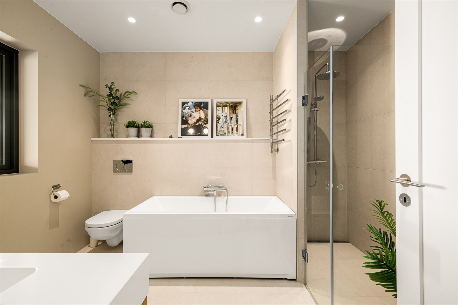 Badet har både badekar og romslig dusjnisje, samt veggmontert toalett. Gulvet har fliser og gulvvarme. Galleribilde