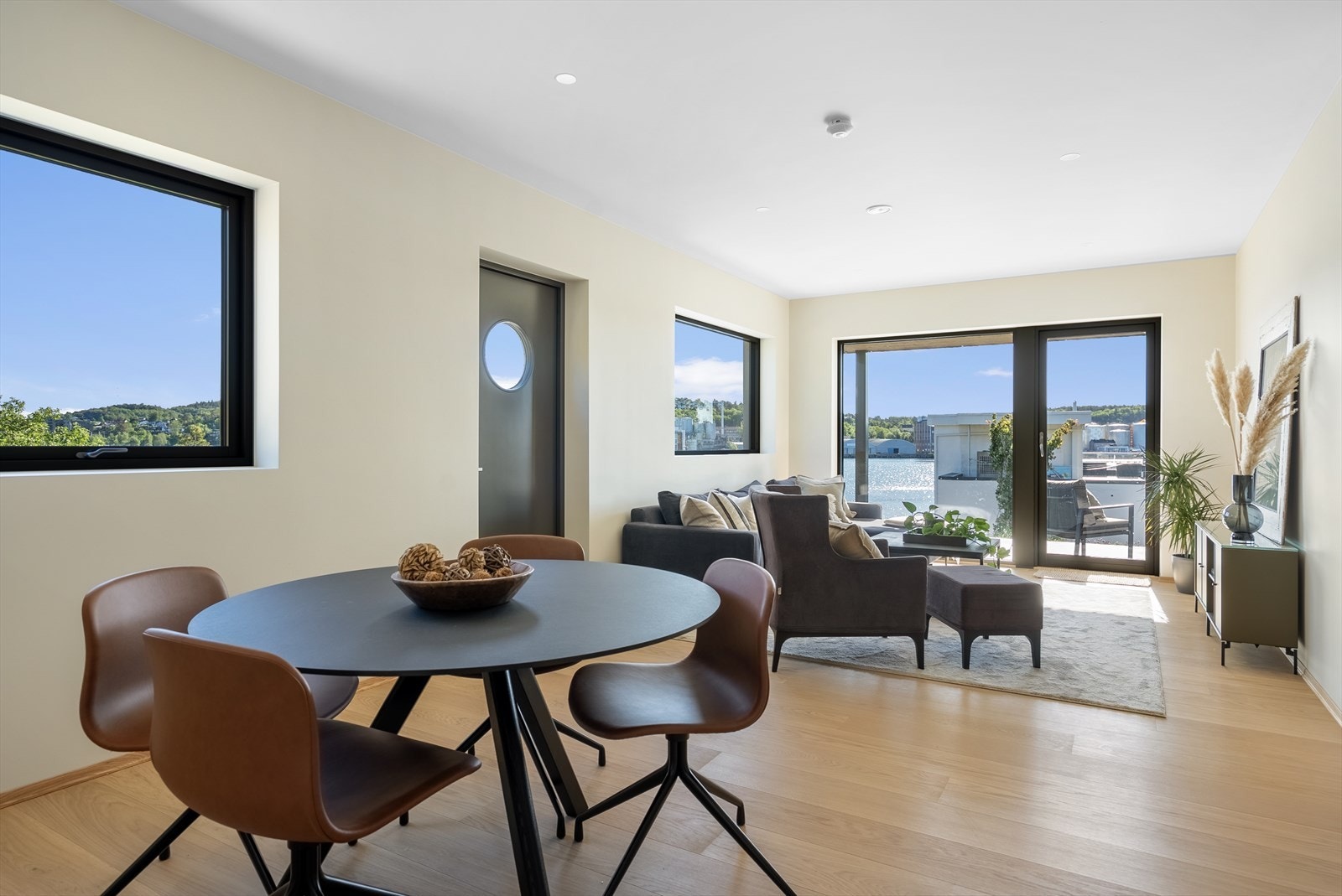 Stue i underetasjen, med plass til både spisebord og sofagruppe, samt utgang til terrasse. Galleribilde