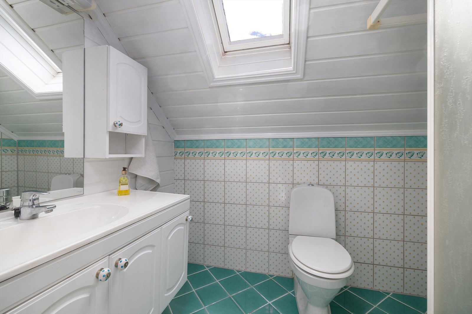 Toalettrom i loftsetasjen med flislagt gulv, dusjhjørne og Velux takvindu. Godkjent toalettrom er omgjort til bad i 1998 men ikke bruksendret. Galleribilde