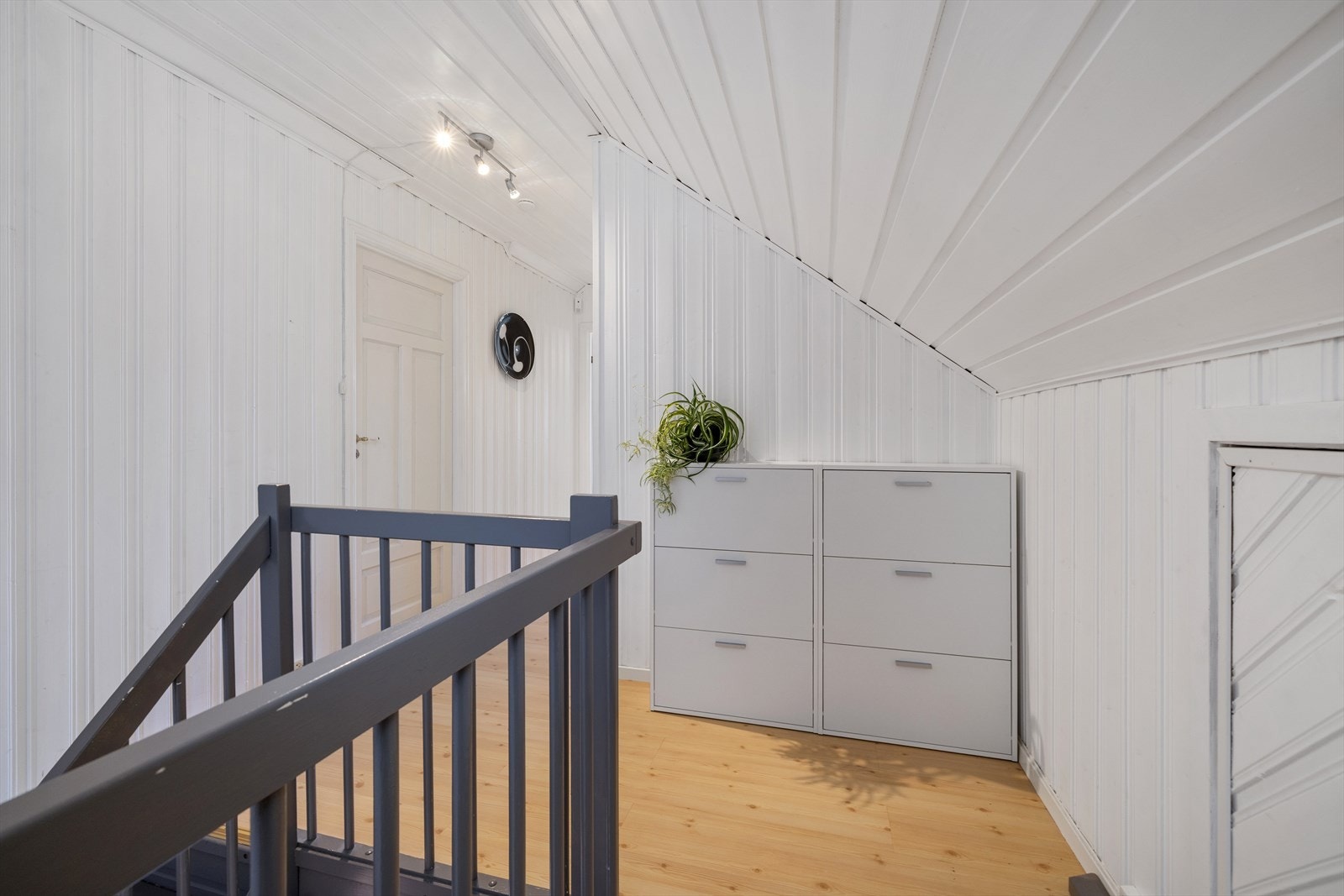 En malt tretrapp leder opp til en lys og åpen loftsetasje. Galleribilde