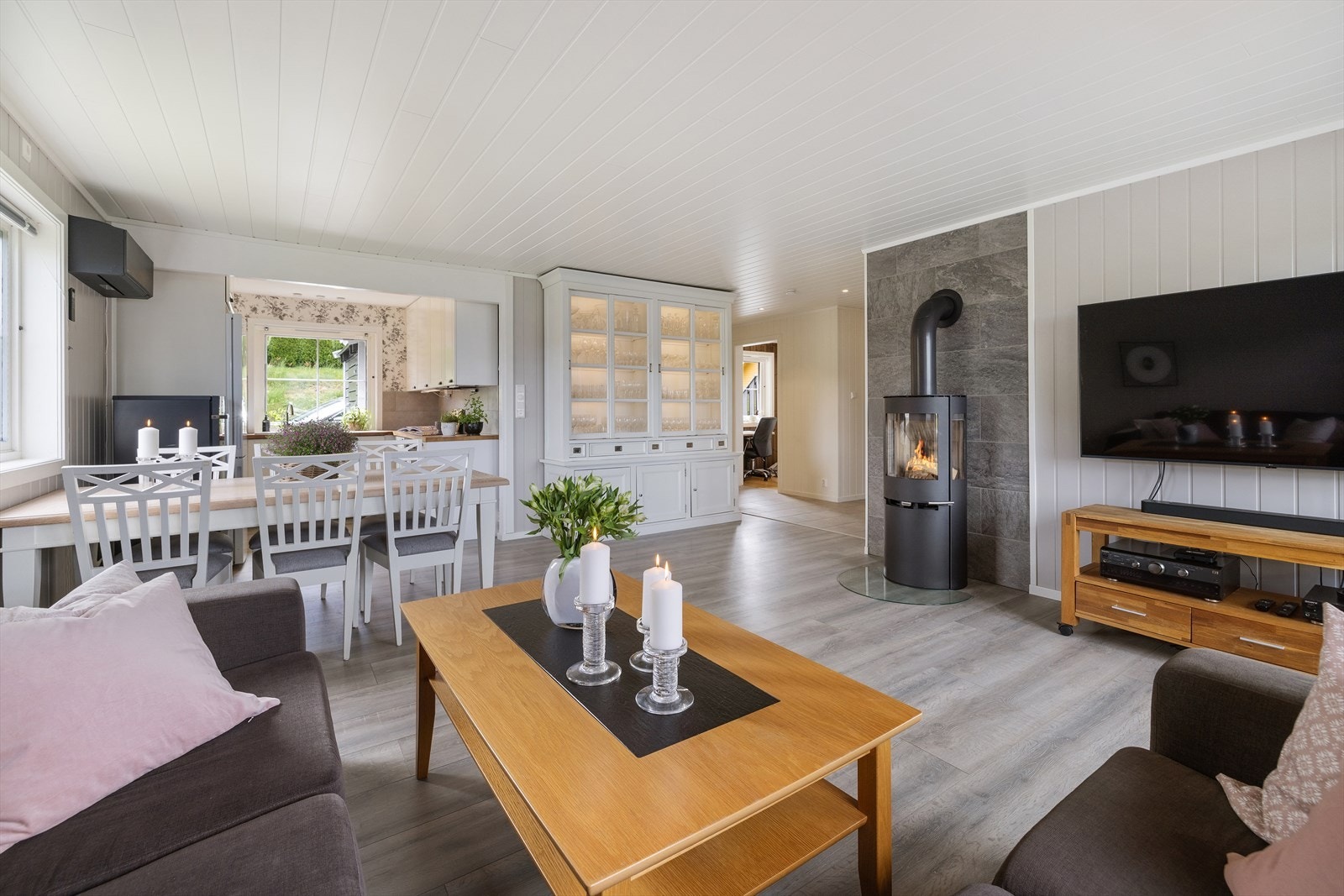 Stuen har god plass til sofagruppe og spisebord, med en effektiv varmepumpe fra 2022. Galleribilde