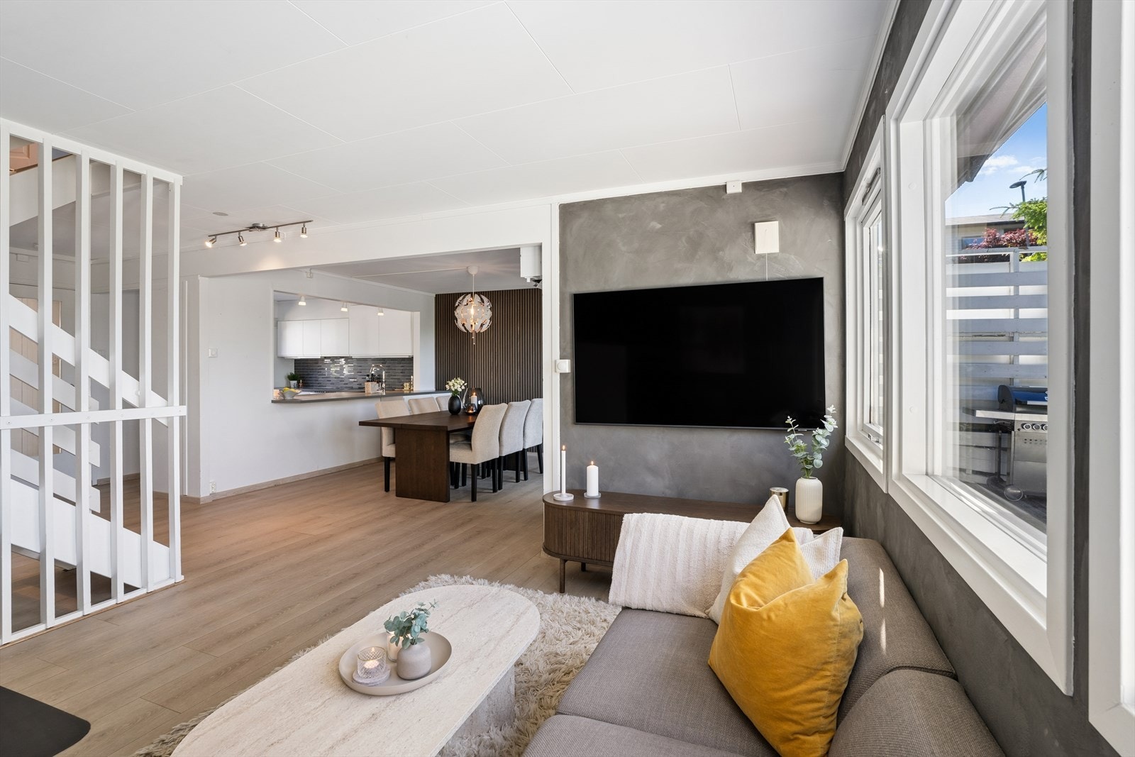 Store vindusflater slipper inn rikelig med dagslys, og skaper en luftig og behagelig atmosfære. Kombinert med moderne fargevalg på veggene fremstår stuen som både innbydende og stilren. Galleribilde